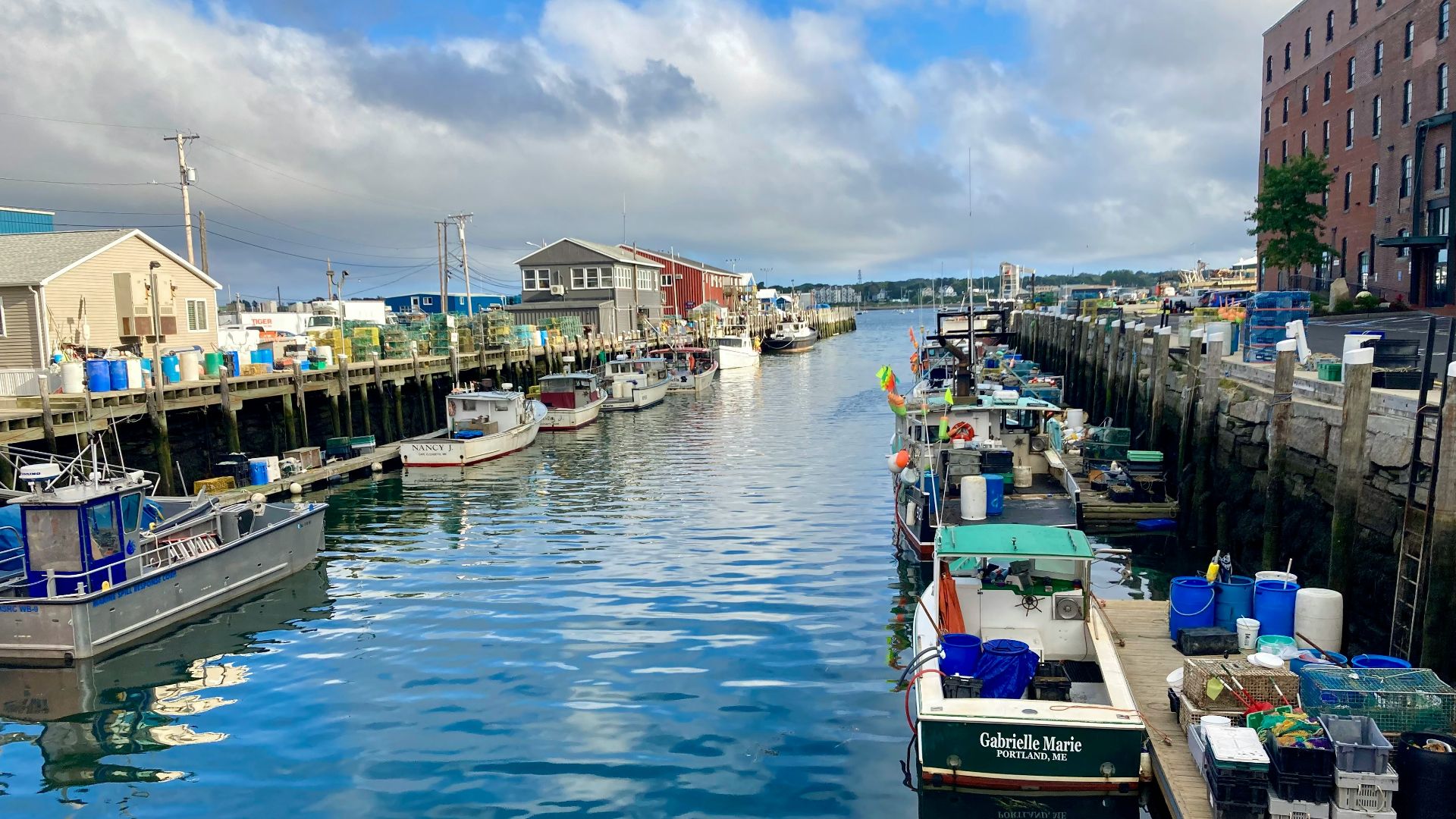 a harbor filled with lots of boats next to tall buildings