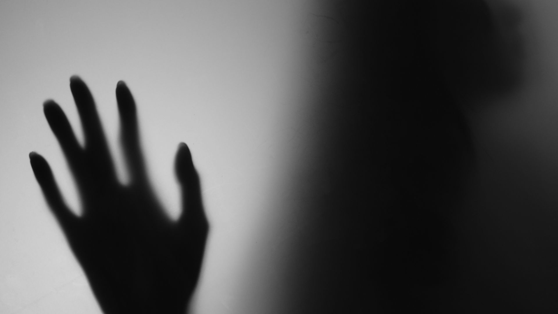 a shadow of a person holding their hand up