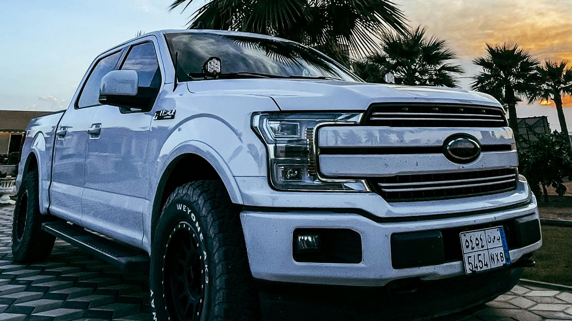 a white truck parked on top of a checkered floor