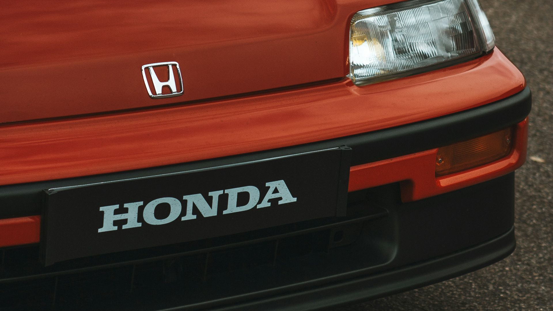 Two honda cars parked next to each other in a parking lot