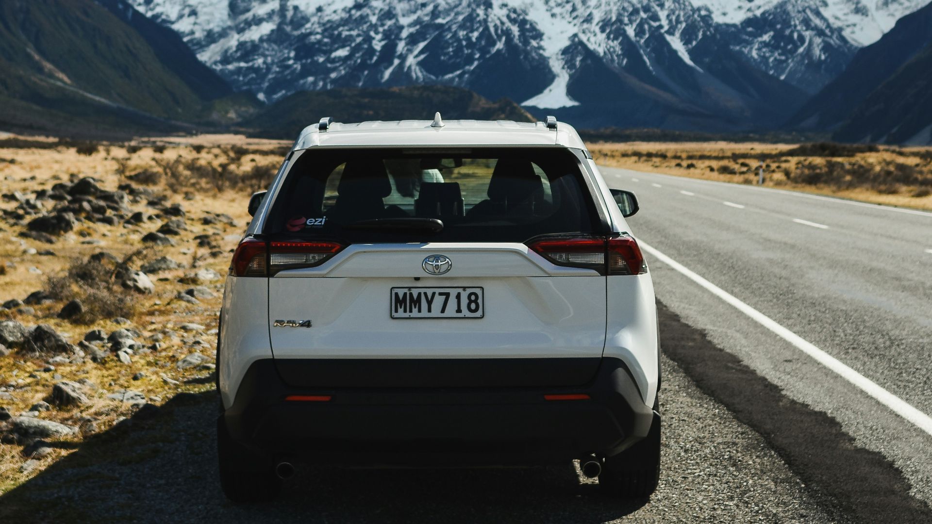 white suv on road near snow covered mountain during daytime