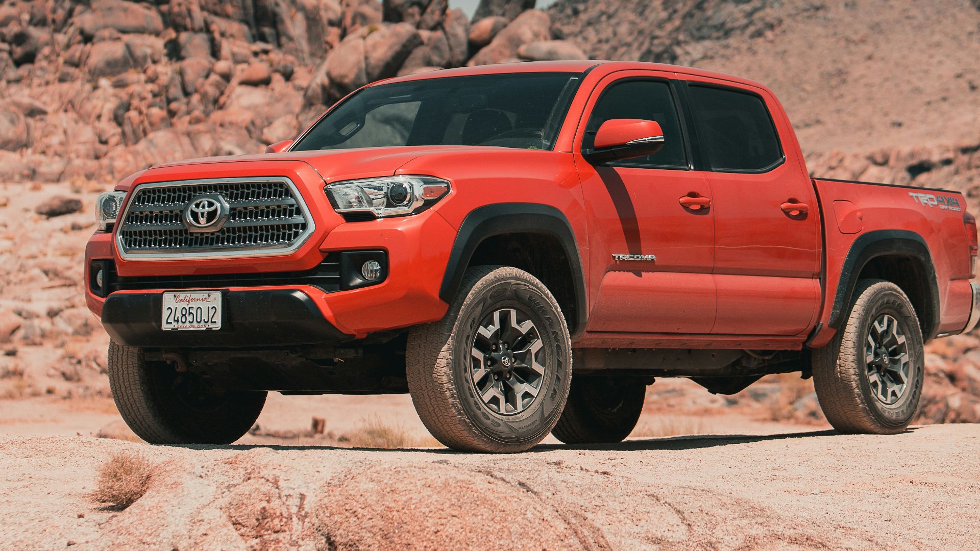 red chevrolet crew cab pickup truck on brown sand