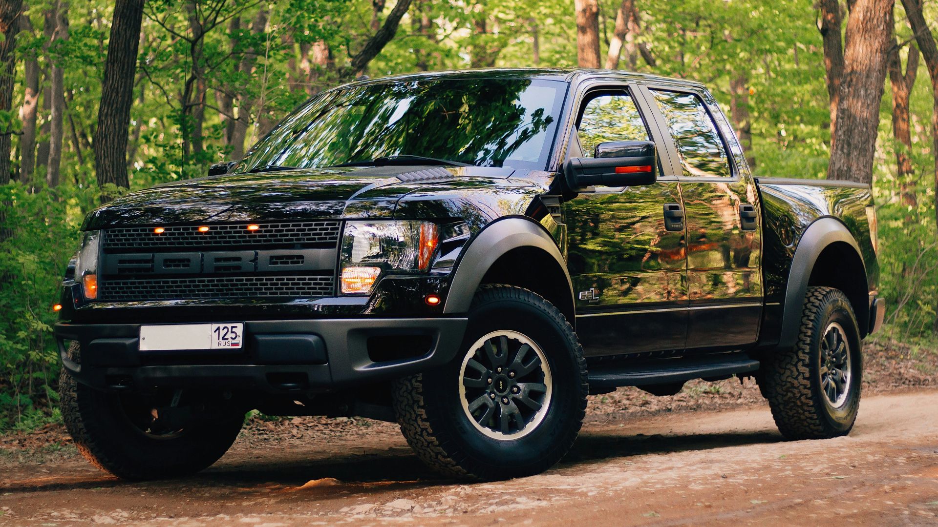 black and yellow chevrolet crew cab pickup truck parked on dirt road during daytime