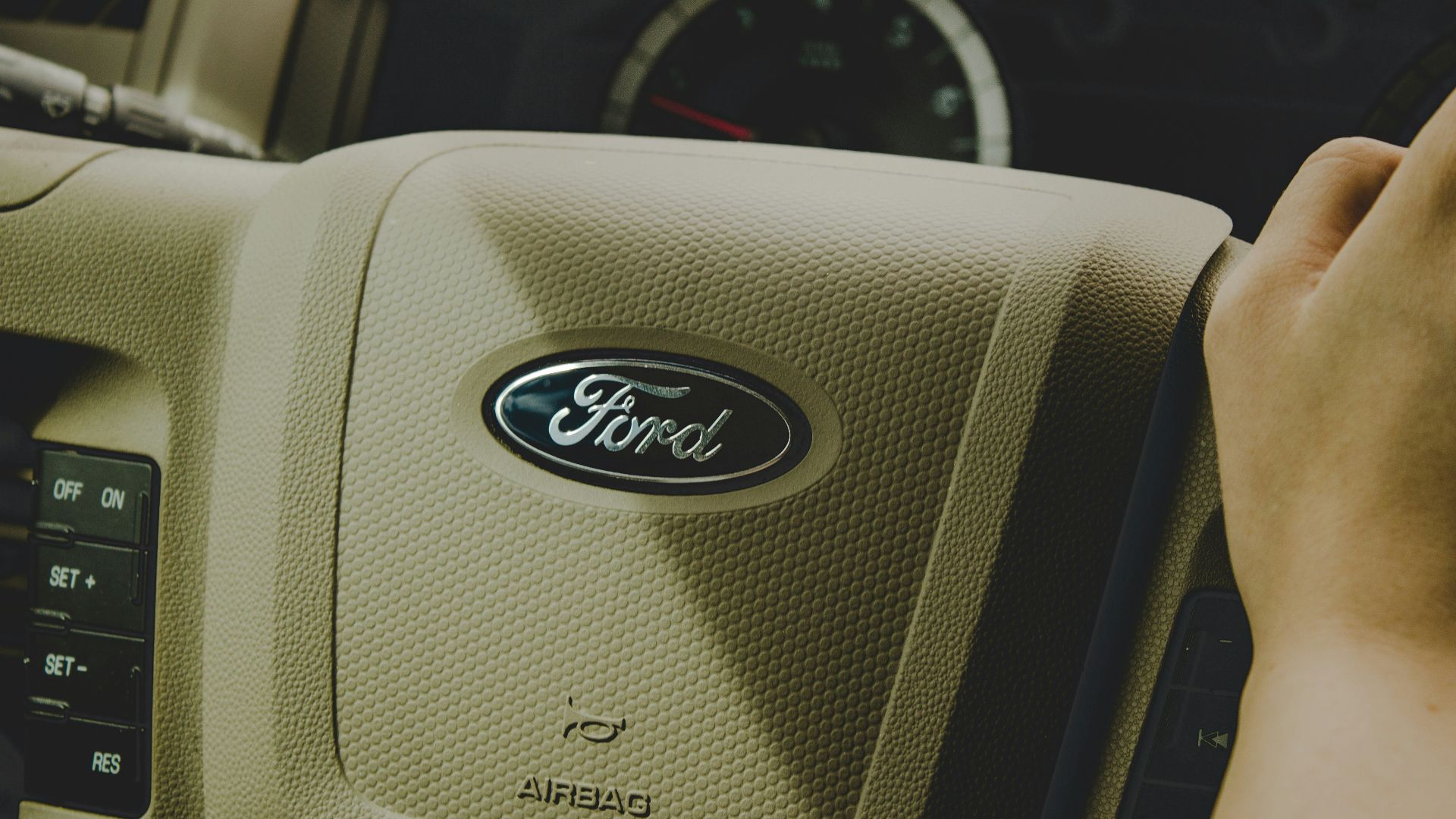 person holding Ford steering wheel