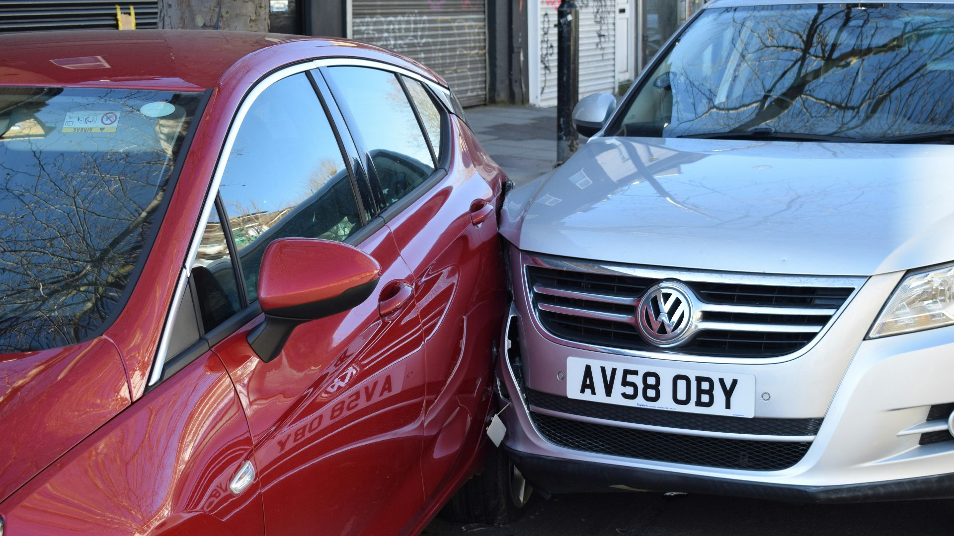 two cars parked next to each other in a parking lot