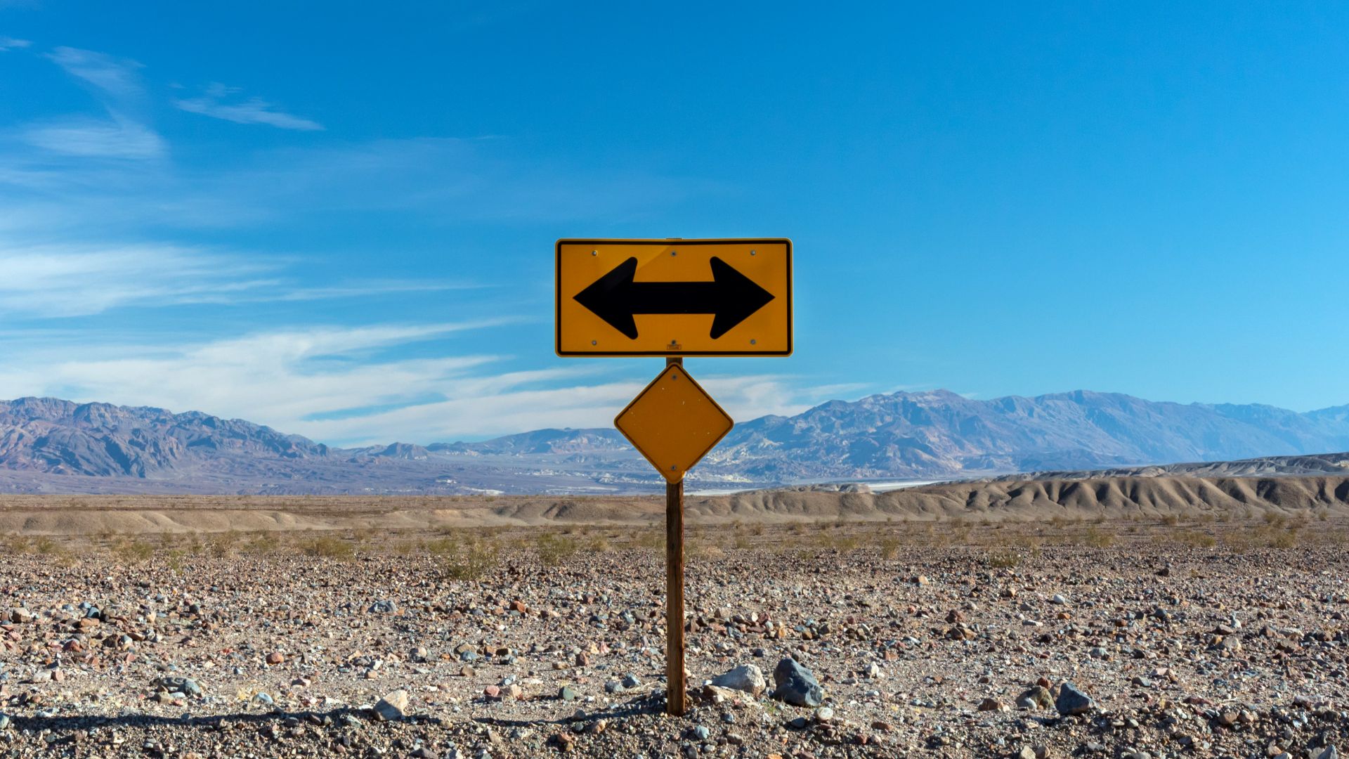 a road sign pointing in opposite directions in the desert