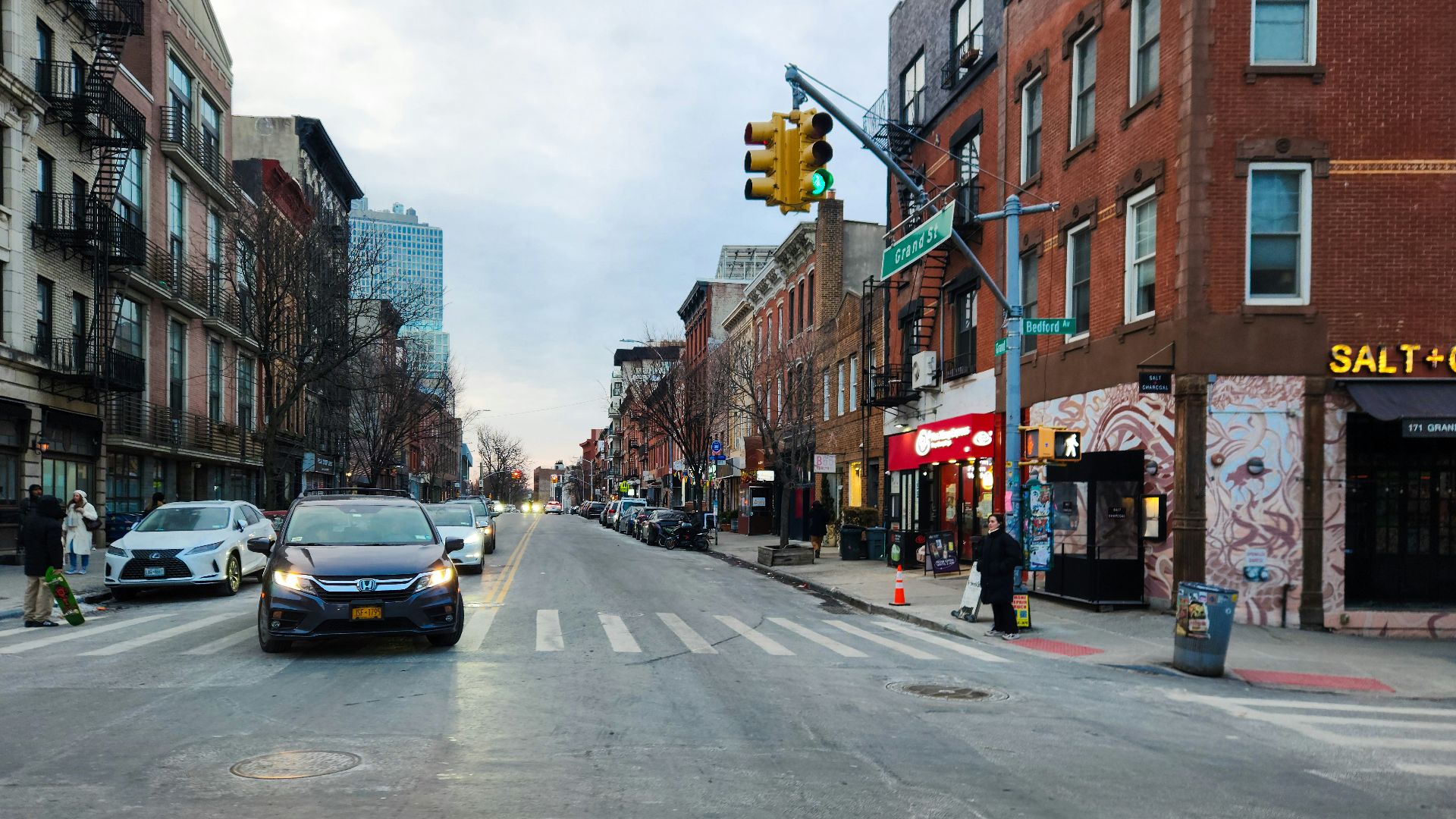 A city street filled with traffic next to tall buildings