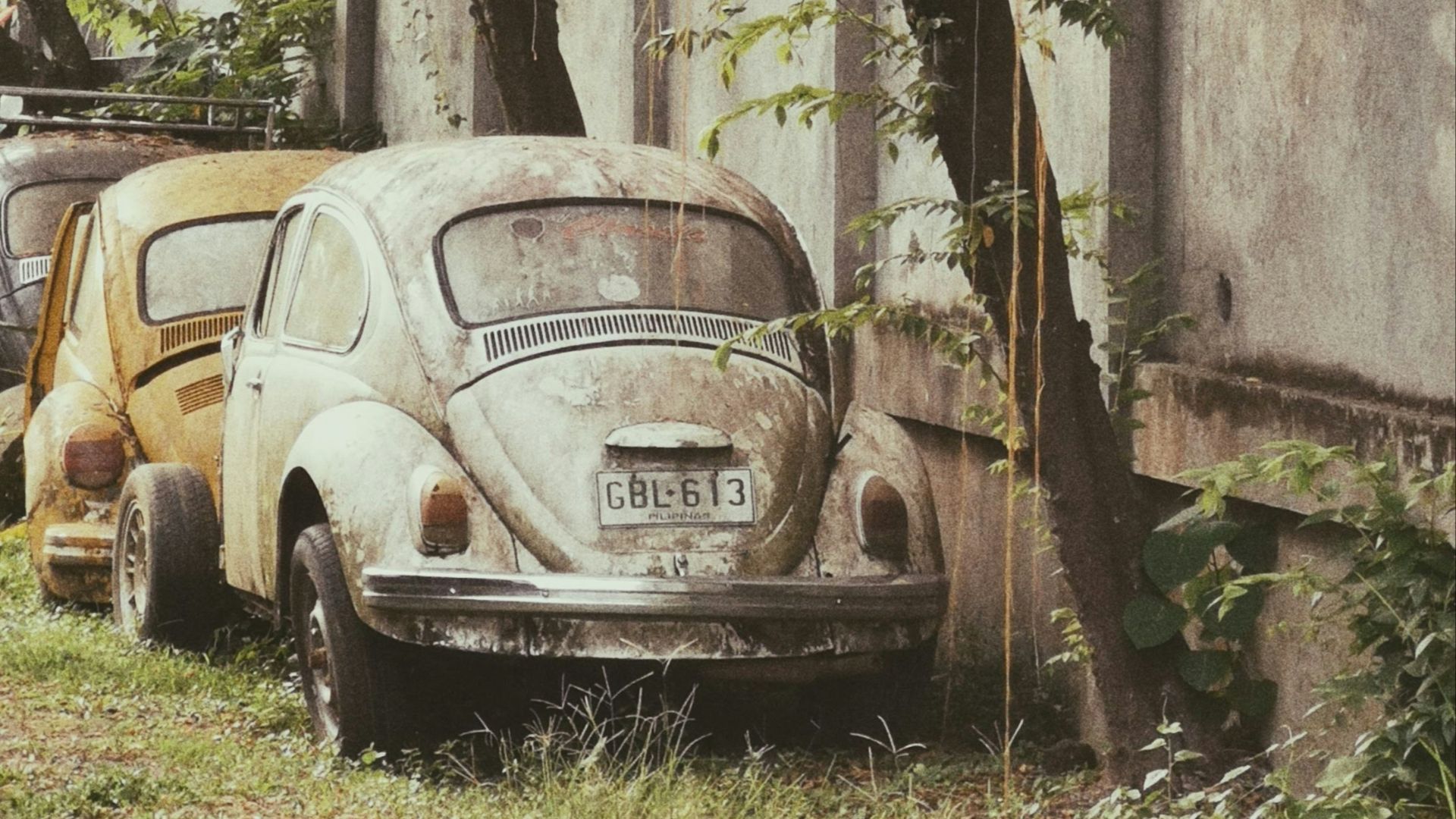 Old volkswagens are parked next to a building.