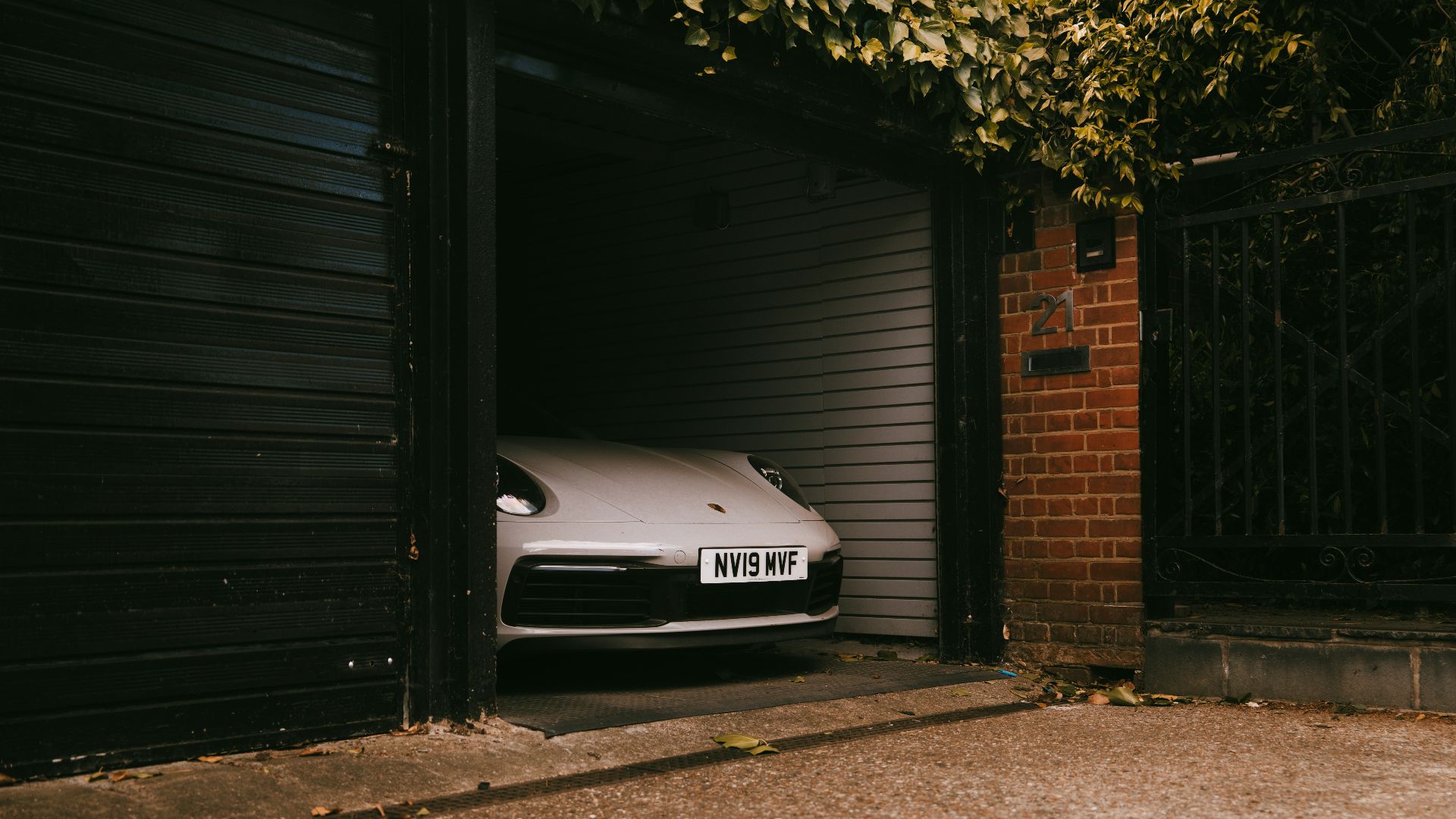 A white car is inside an open garage.