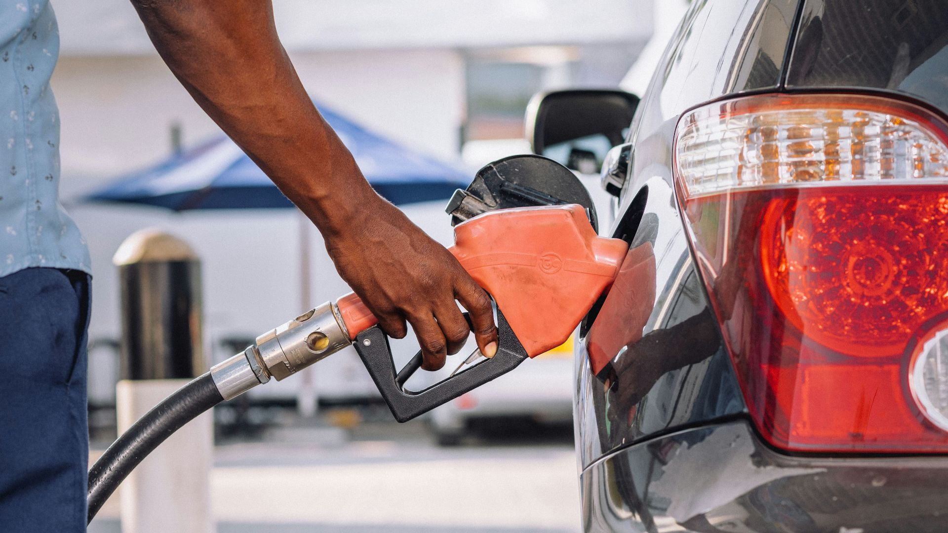 a man pumping gas into his car at a gas station