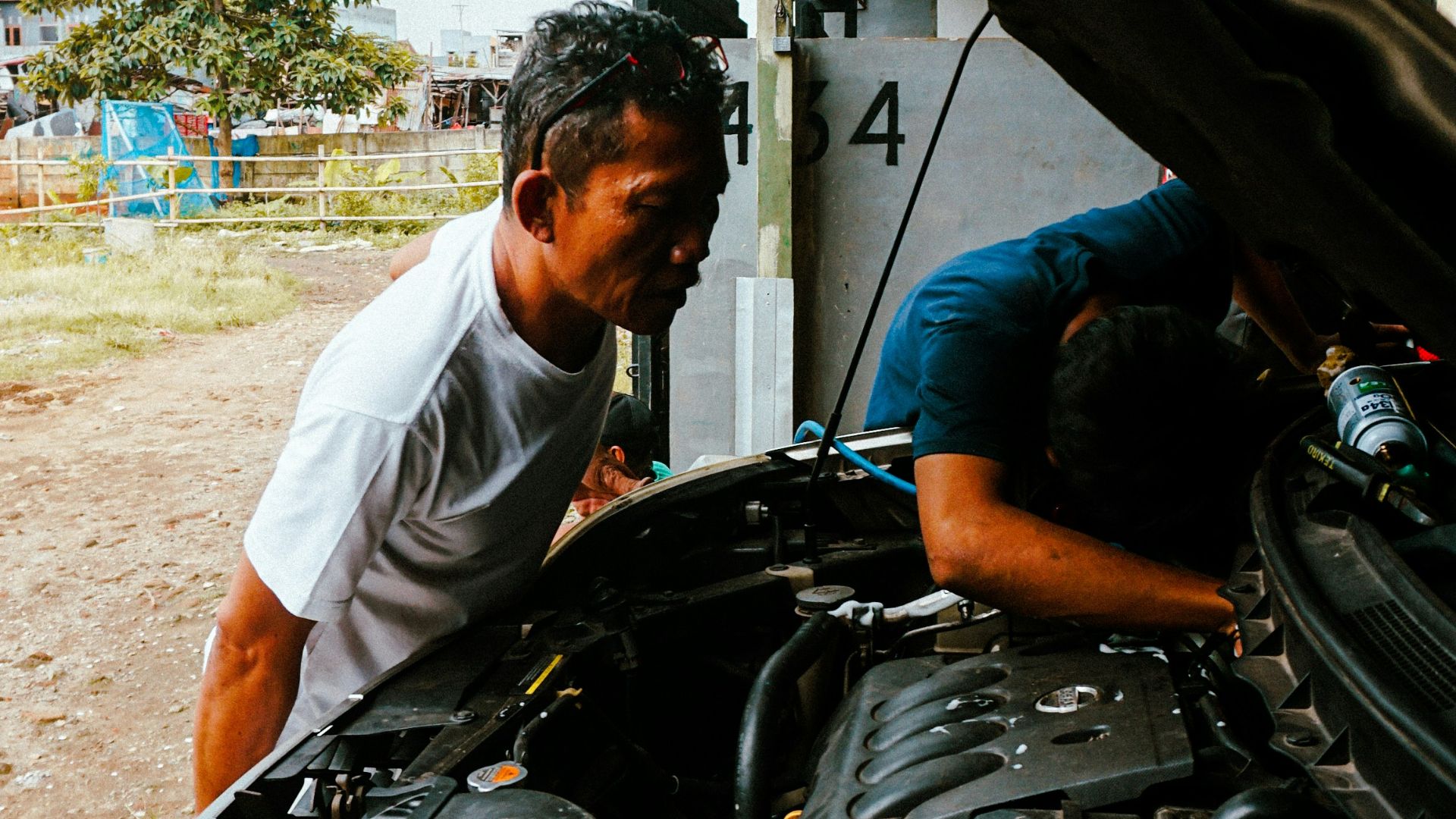 a man working on a car engine in a garage