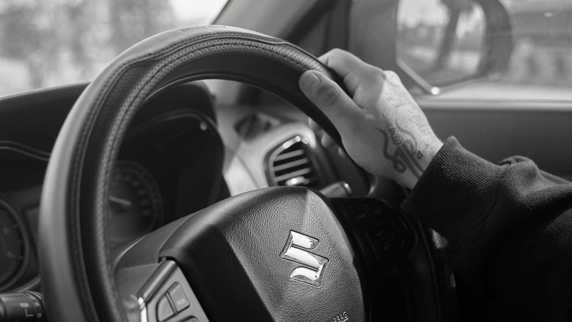 a black and white photo of a person driving a car