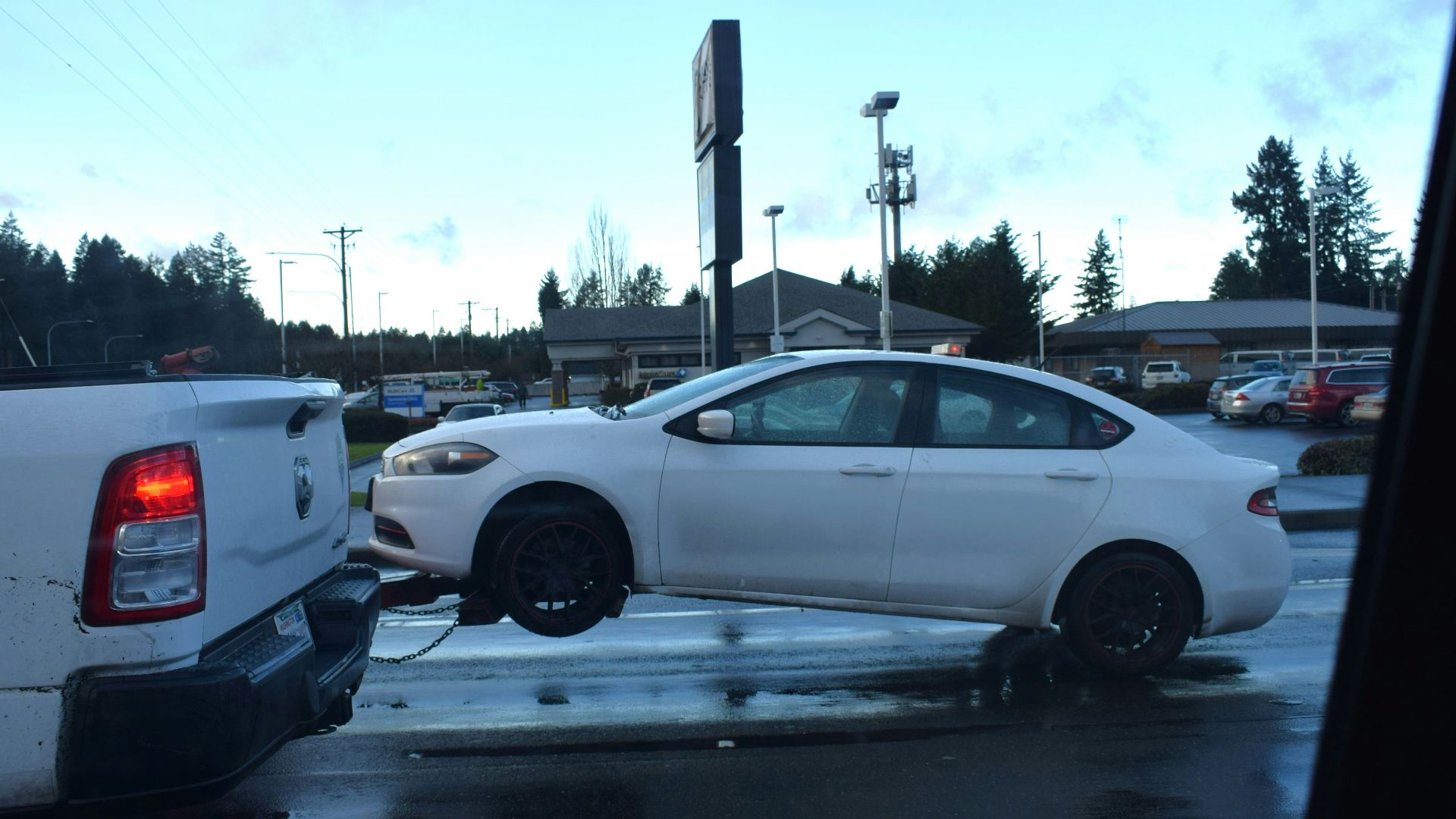 a white car being towed by a tow truck