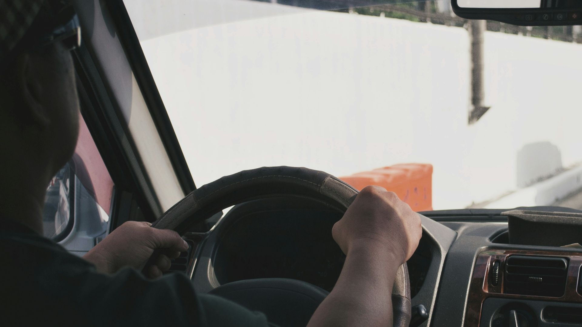 person driving vehicle on road near vehicle at daytime