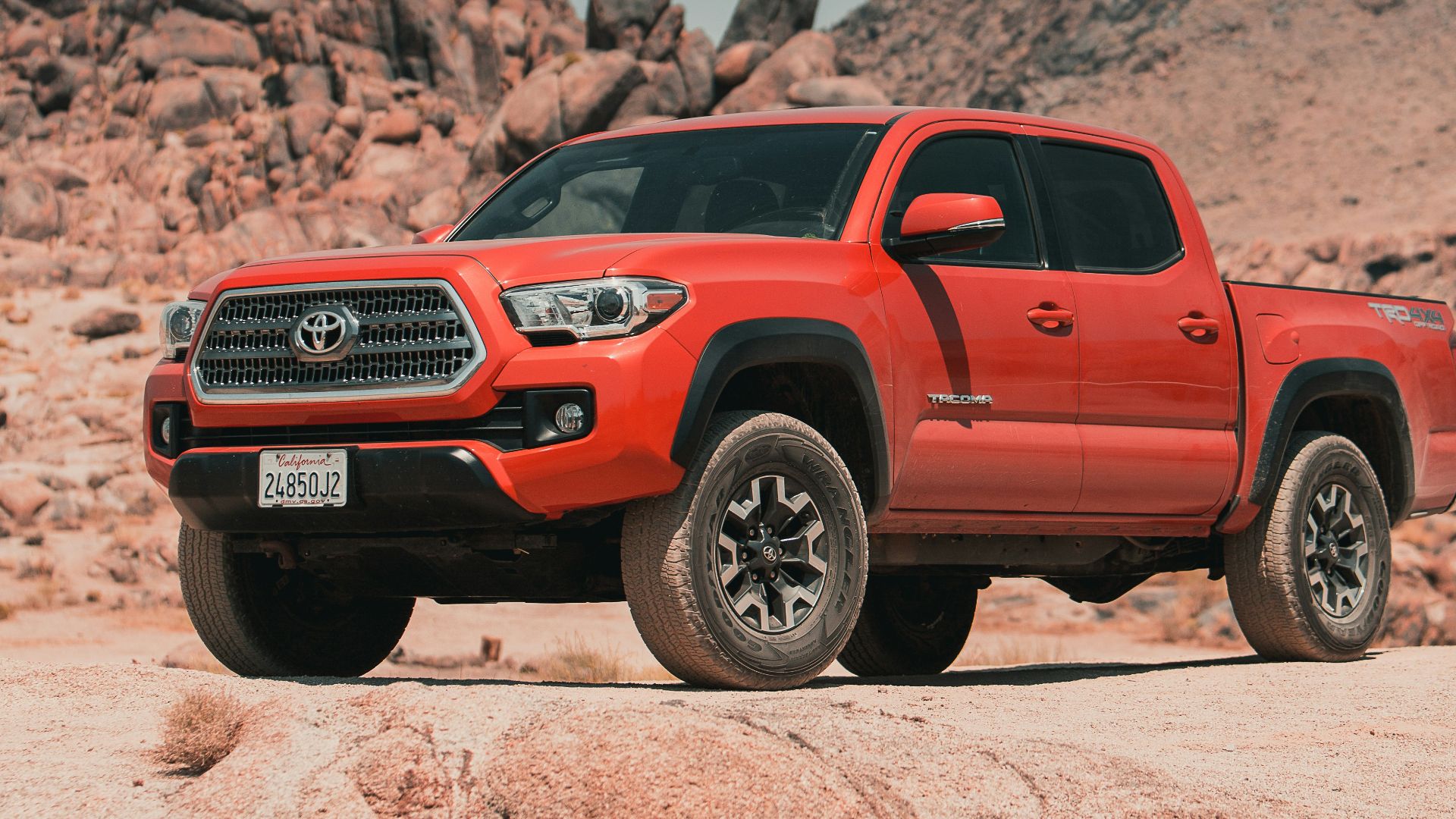 red chevrolet crew cab pickup truck on brown sand