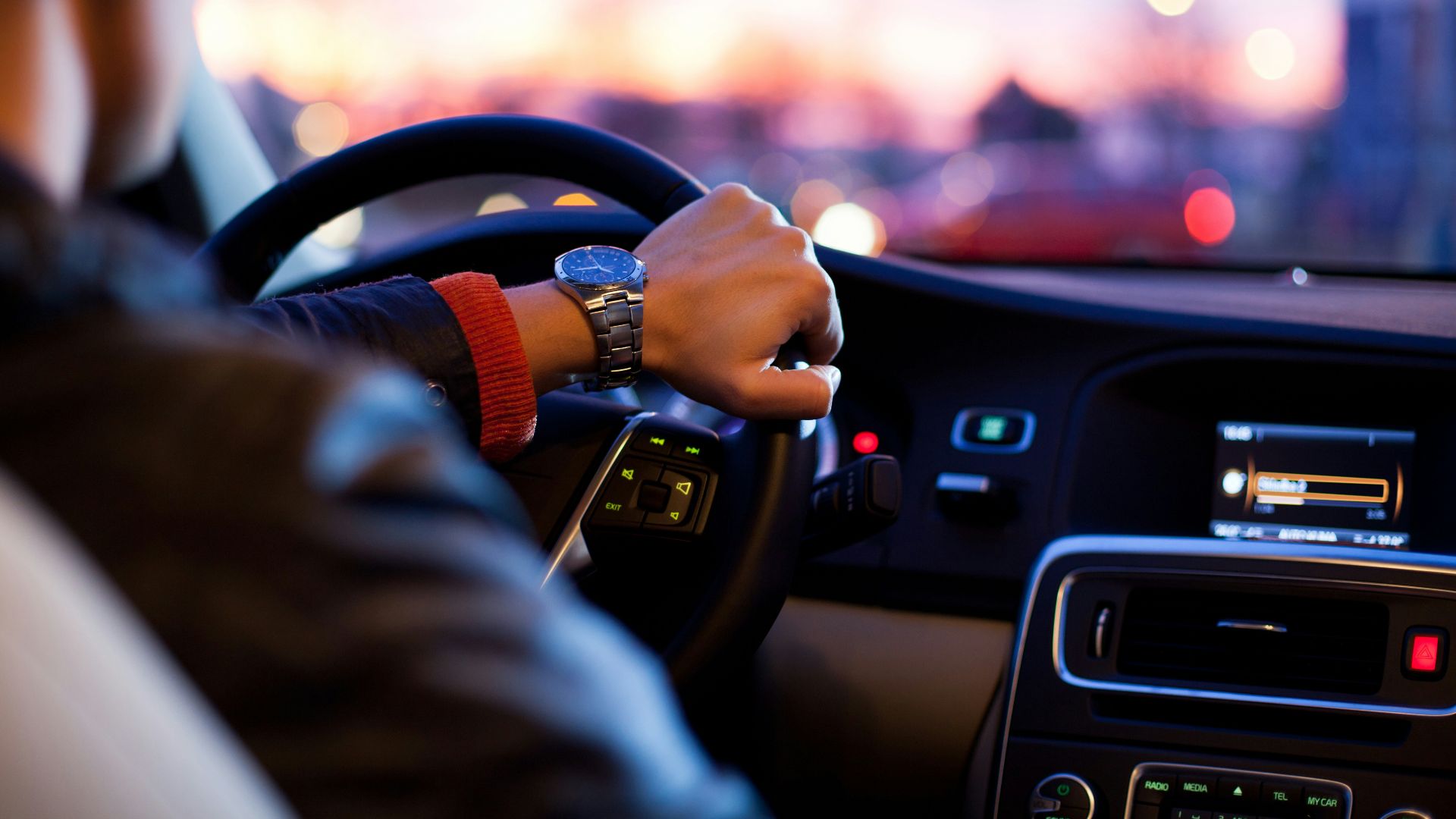 man driving a car wearing wrist watch