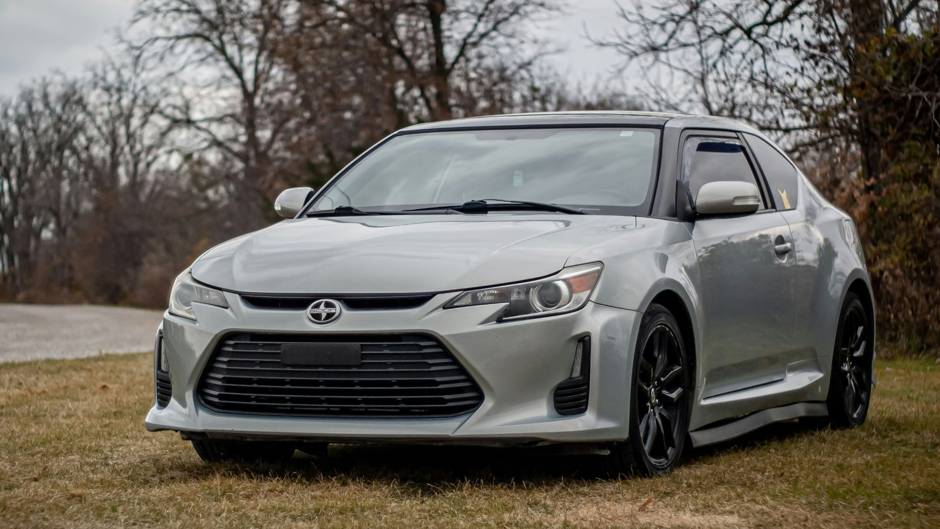 a silver car is parked on the grass