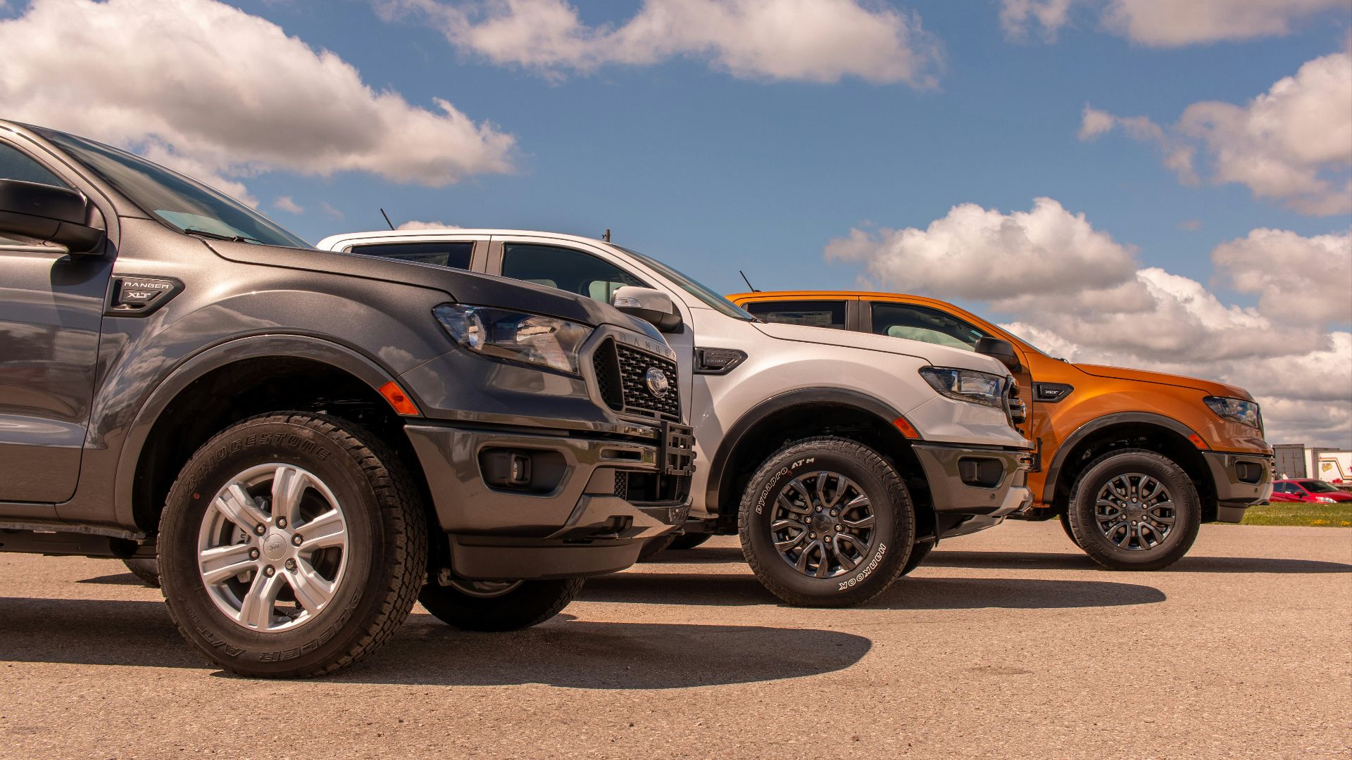 white and black suv on gray asphalt road under blue and white sunny cloudy sky during