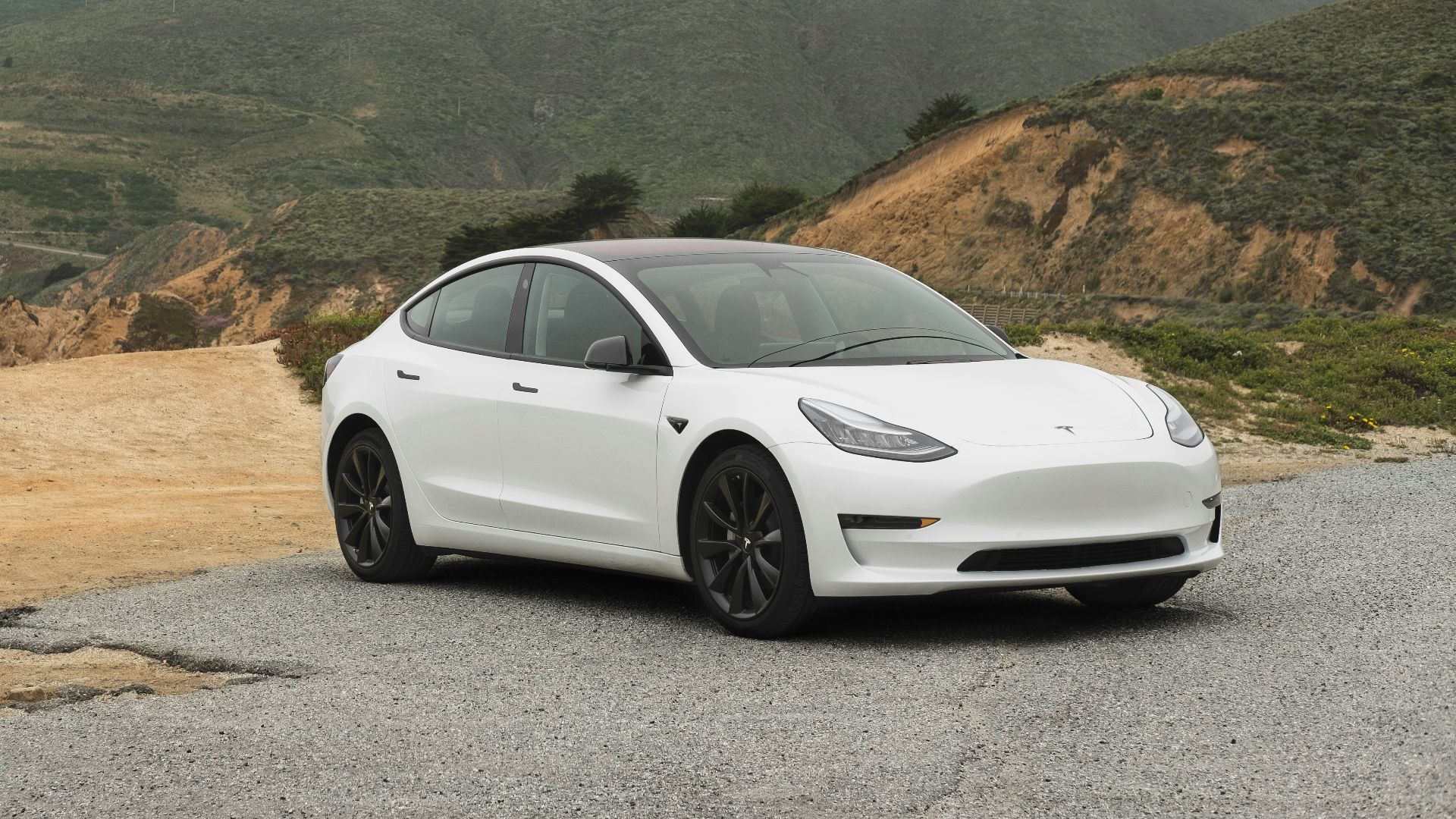 white sedan parked beside mountain during daytime