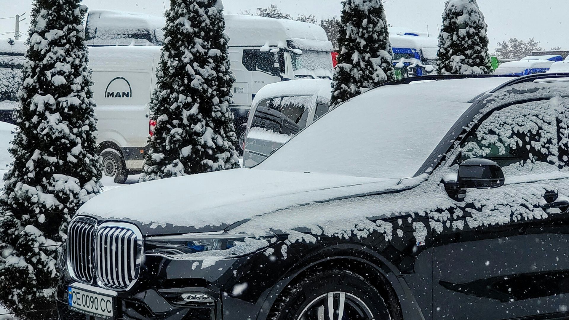 a car is covered in snow in a parking lot