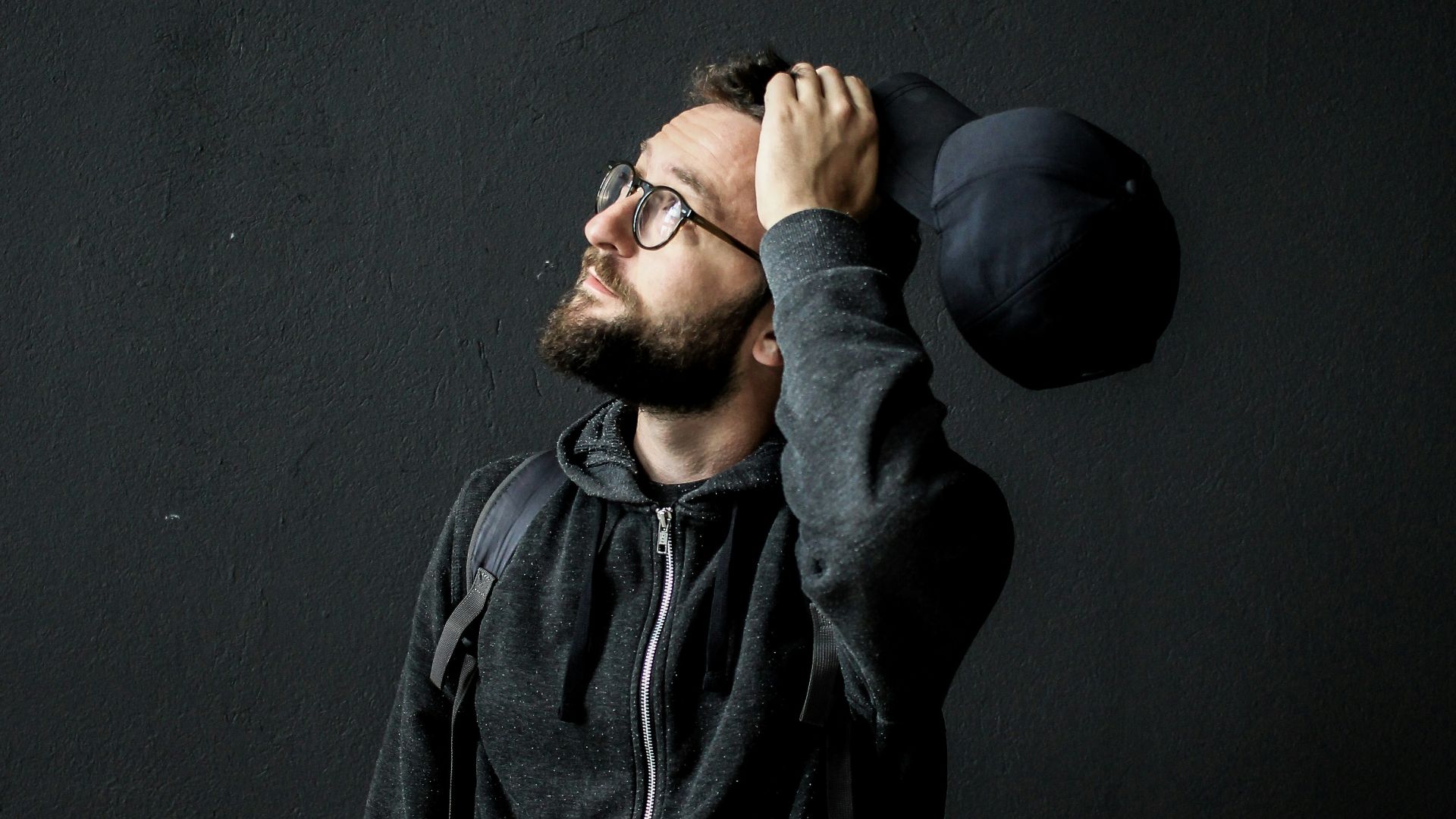 man looking up holding his hair