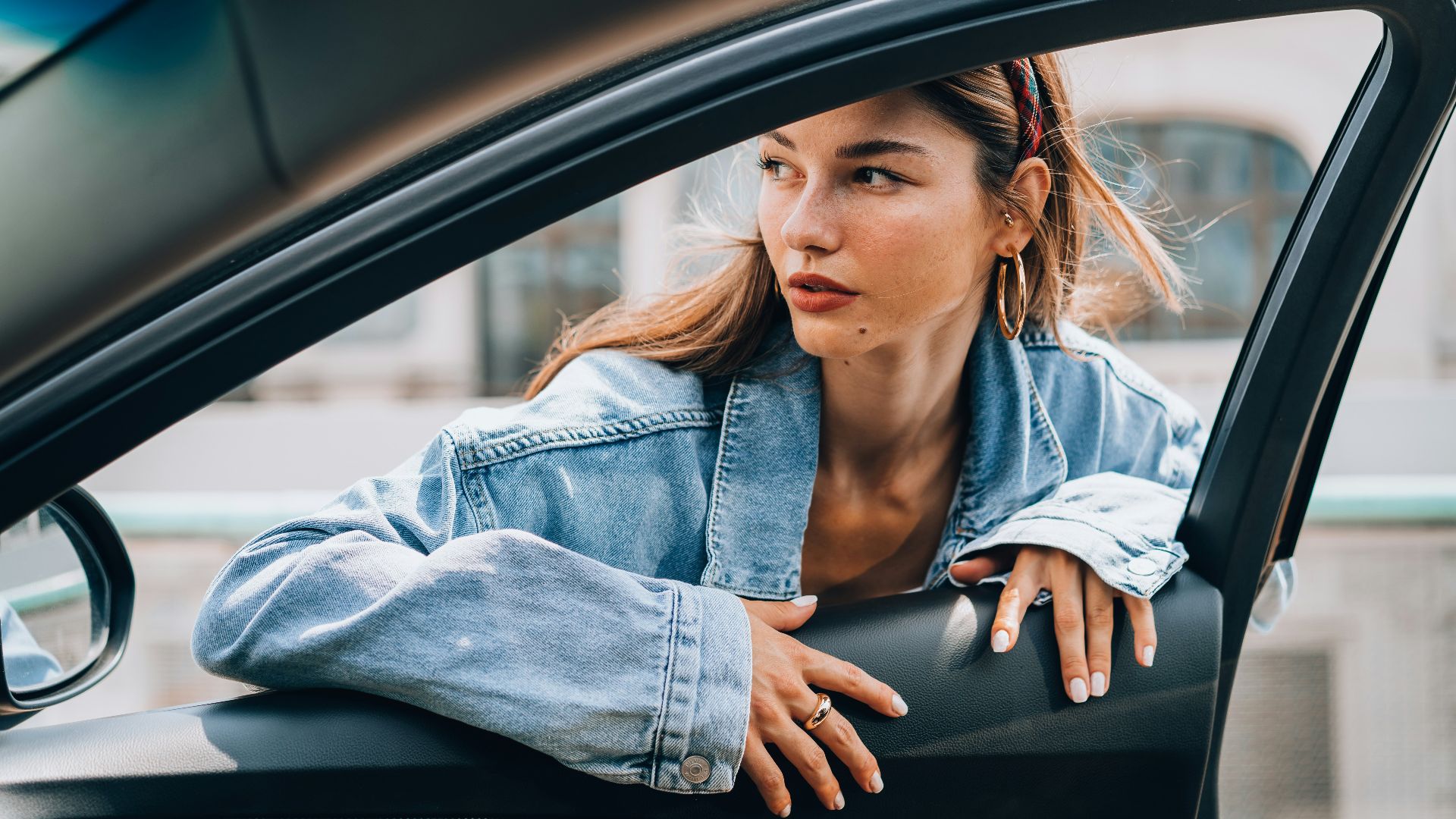 a woman sitting in a car looking out the window