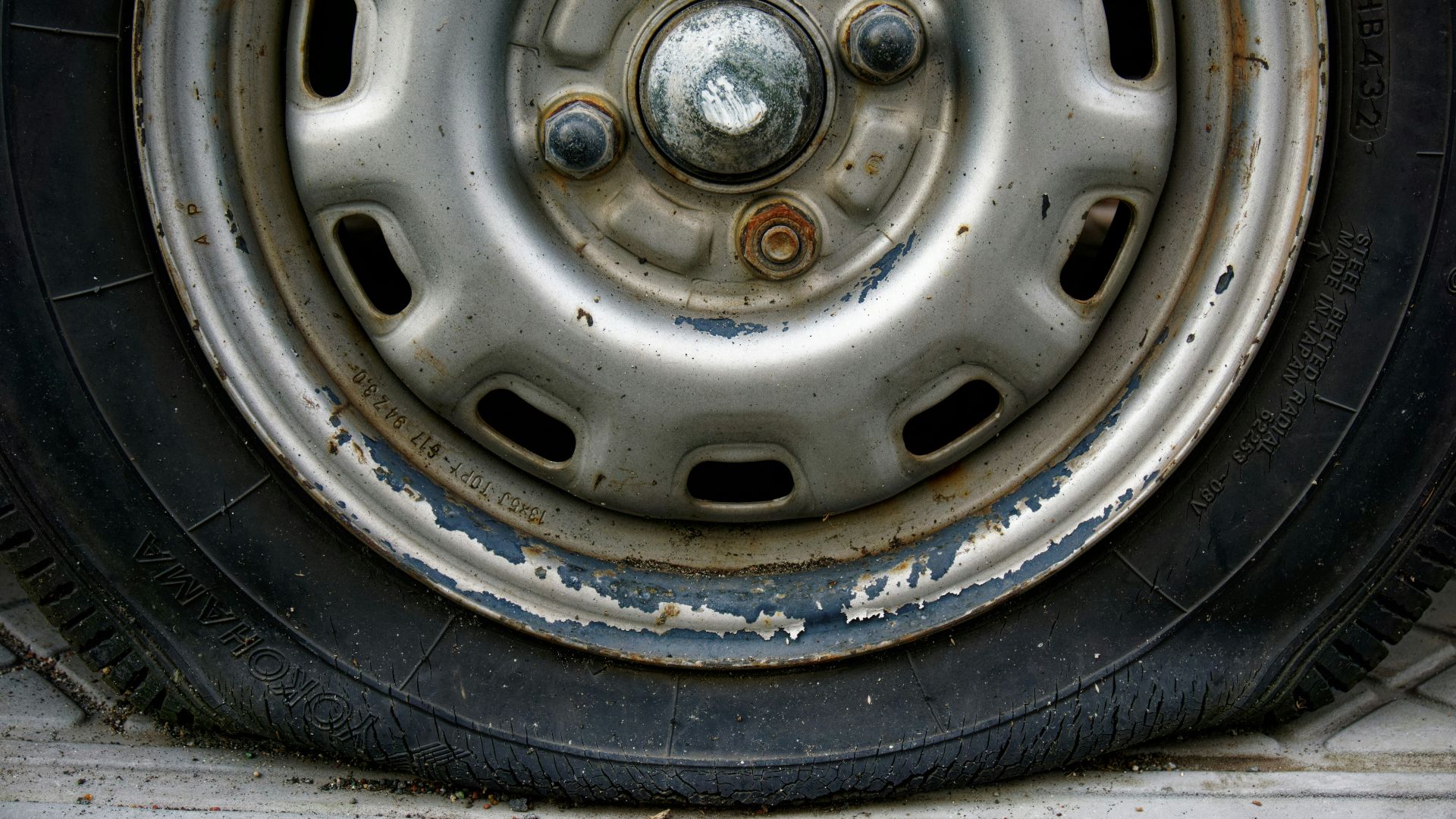Close-up of a worn car tire and rim.