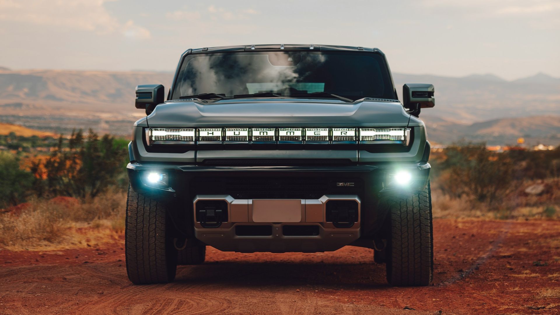 A pick up truck driving down a dirt road