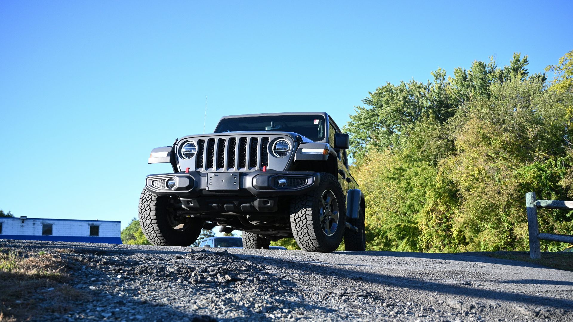 a black jeep driving down a road next to a forest
