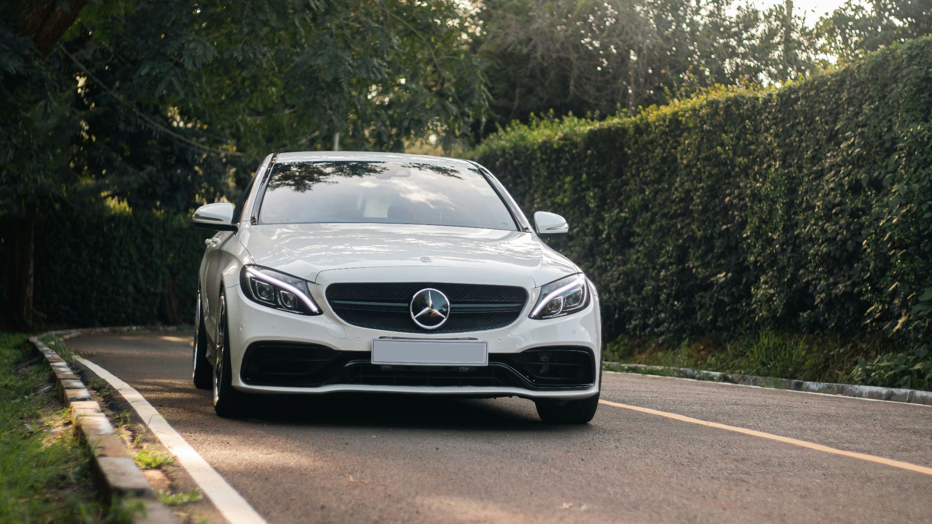 a white car is driving down the road