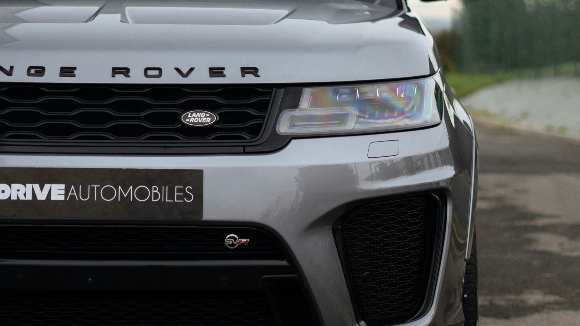 a silver range rover parked in front of a building