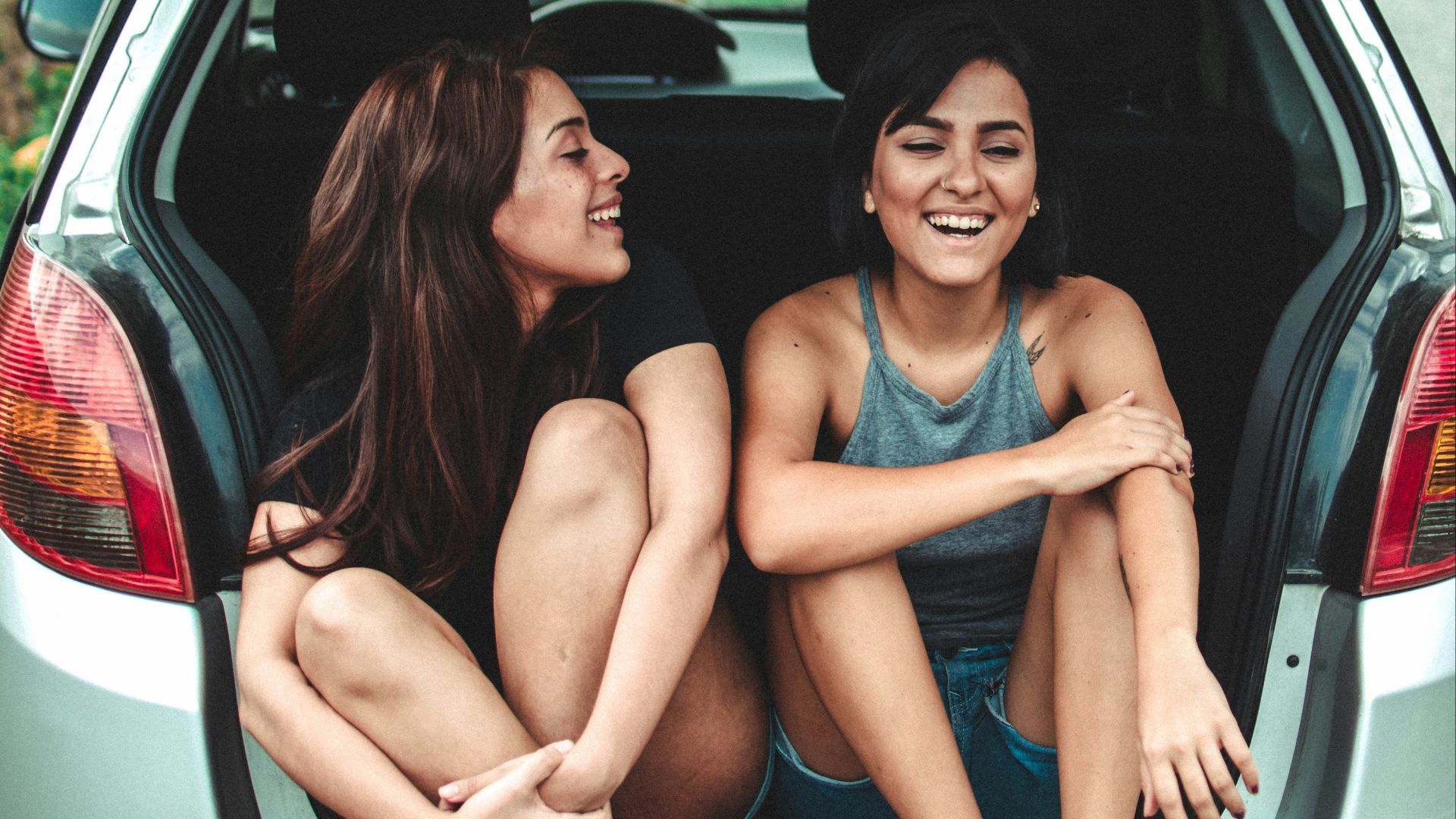 two women sitting at the back of the car