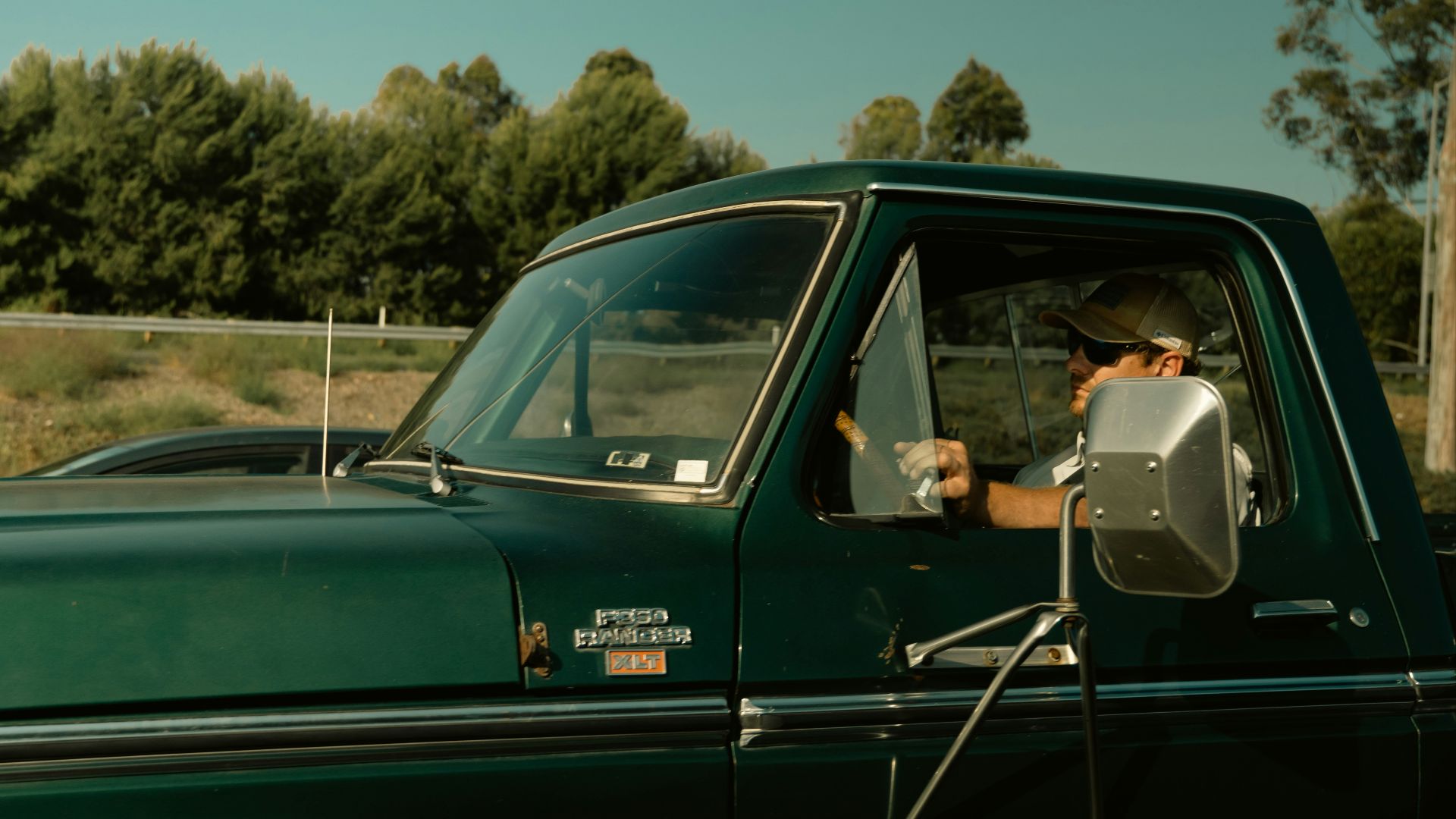 Man driving a green vintage pickup truck