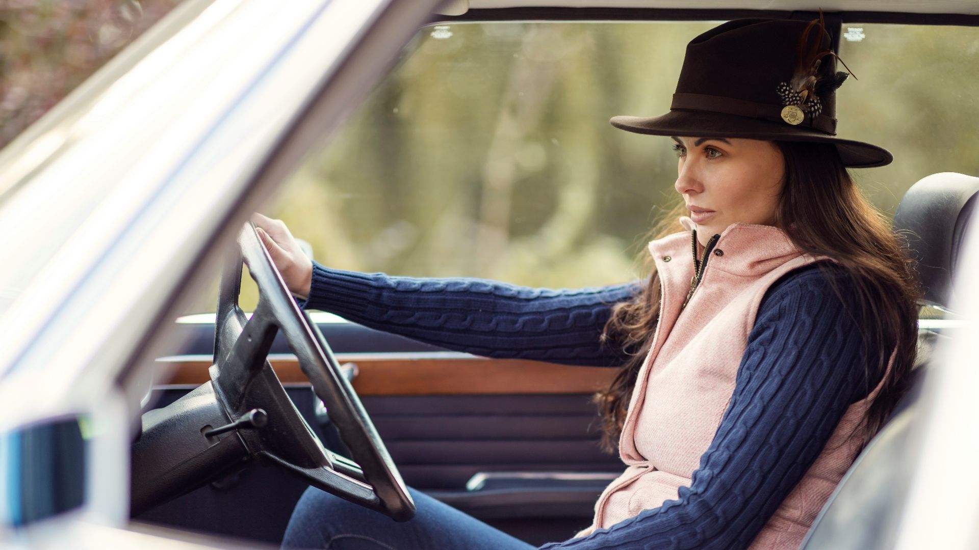 a woman wearing a hat sitting in a car