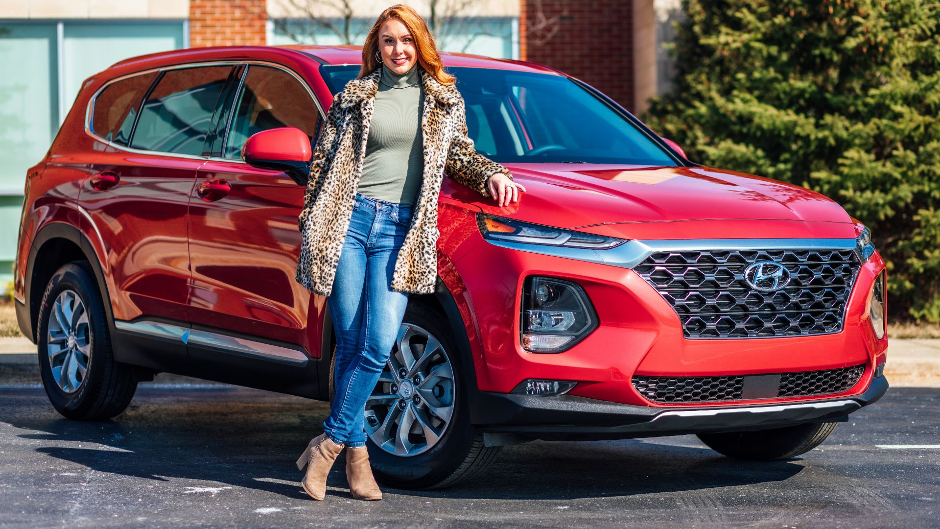 woman in white and black scarf and blue denim jeans standing beside red mercedes benz car