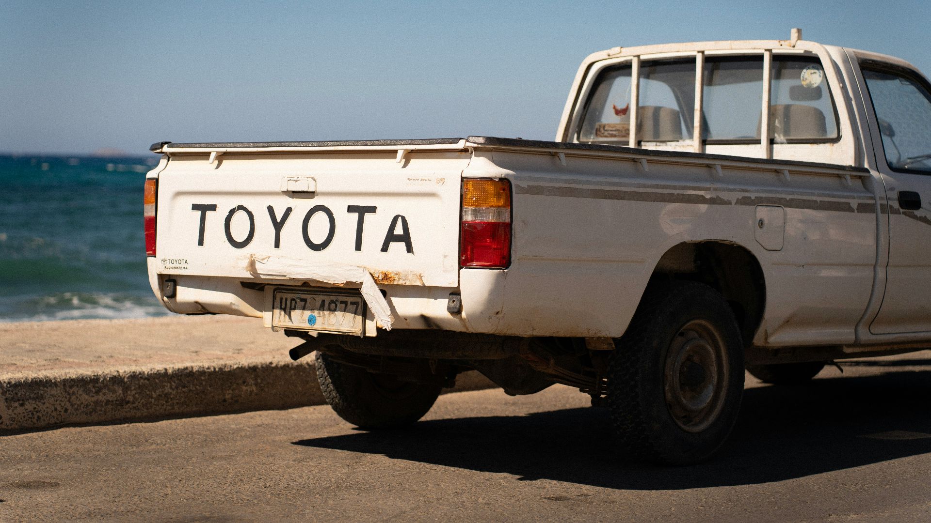 White toyota pickup truck parked by the ocean