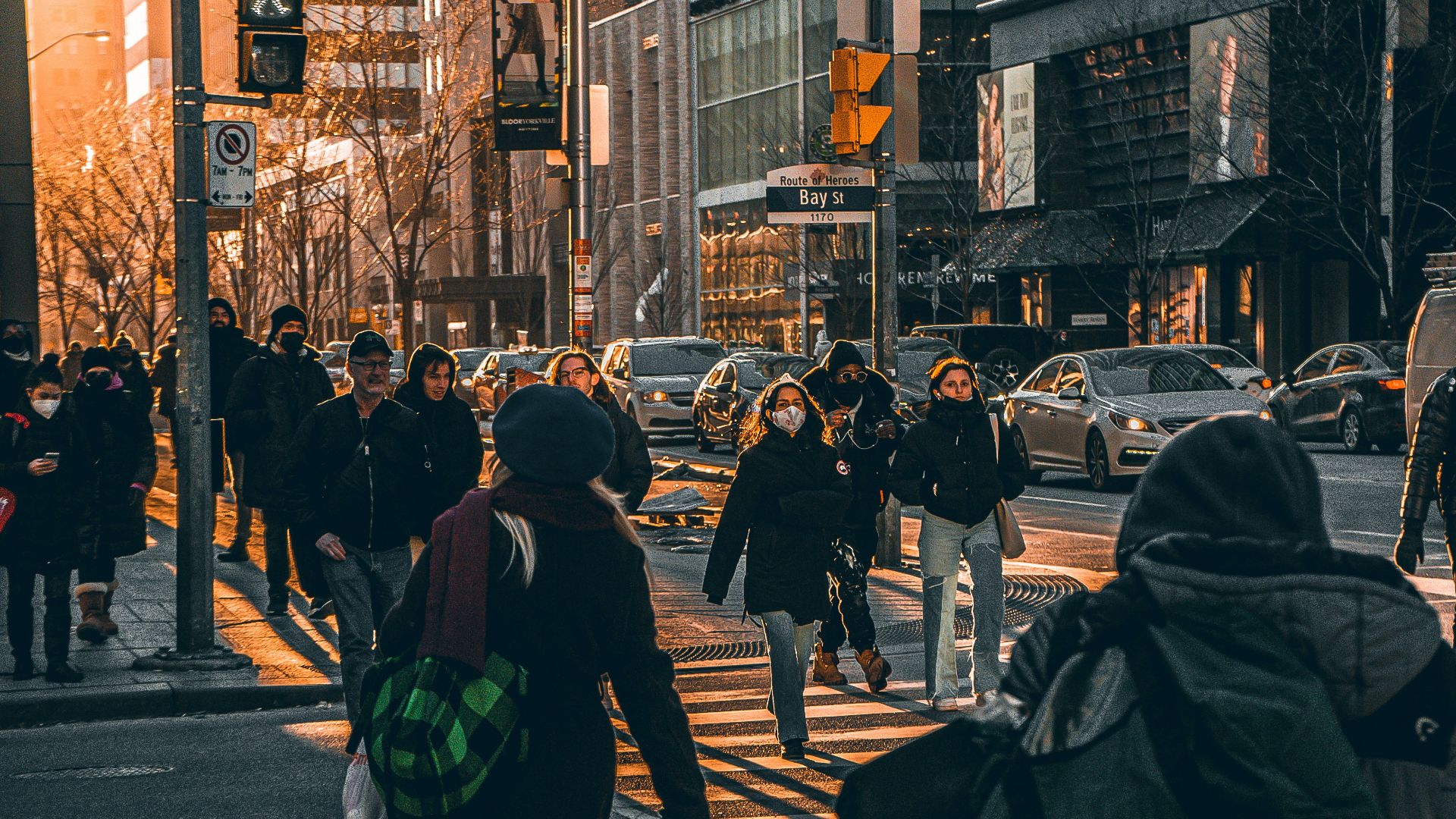 a group of people walking down a street next to tall buildings
