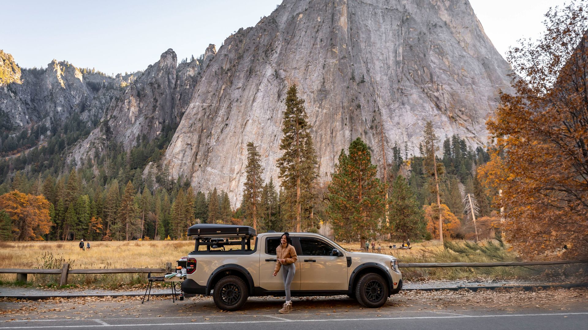 Man leaning on truck with mountain backdrop