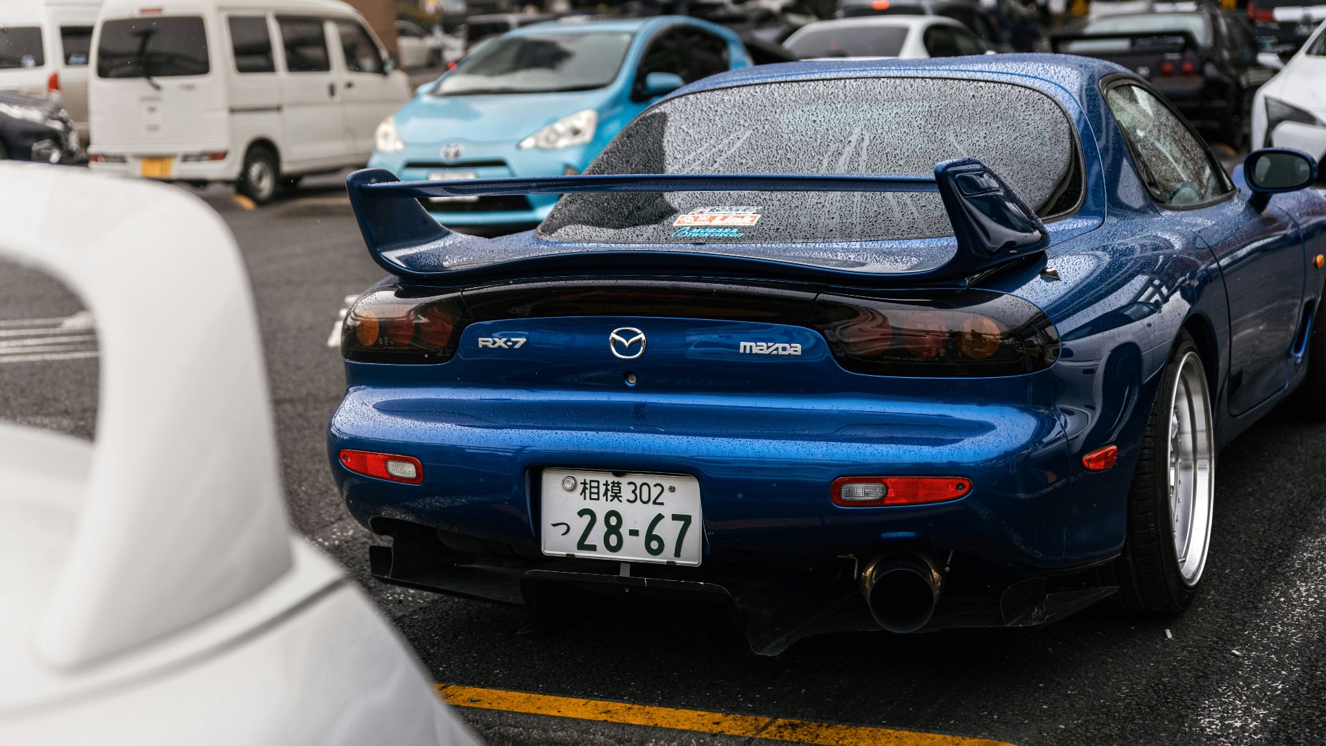 Blue mazda rx-7 sports car parked in lot.
