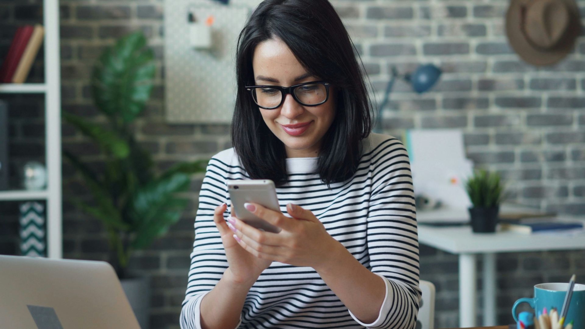 a woman sitting at a table looking at her cell phone