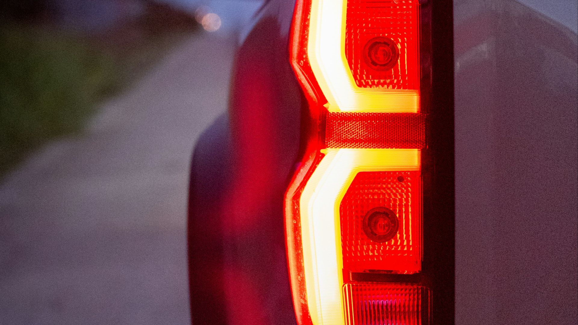 The tail lights of a white pickup truck