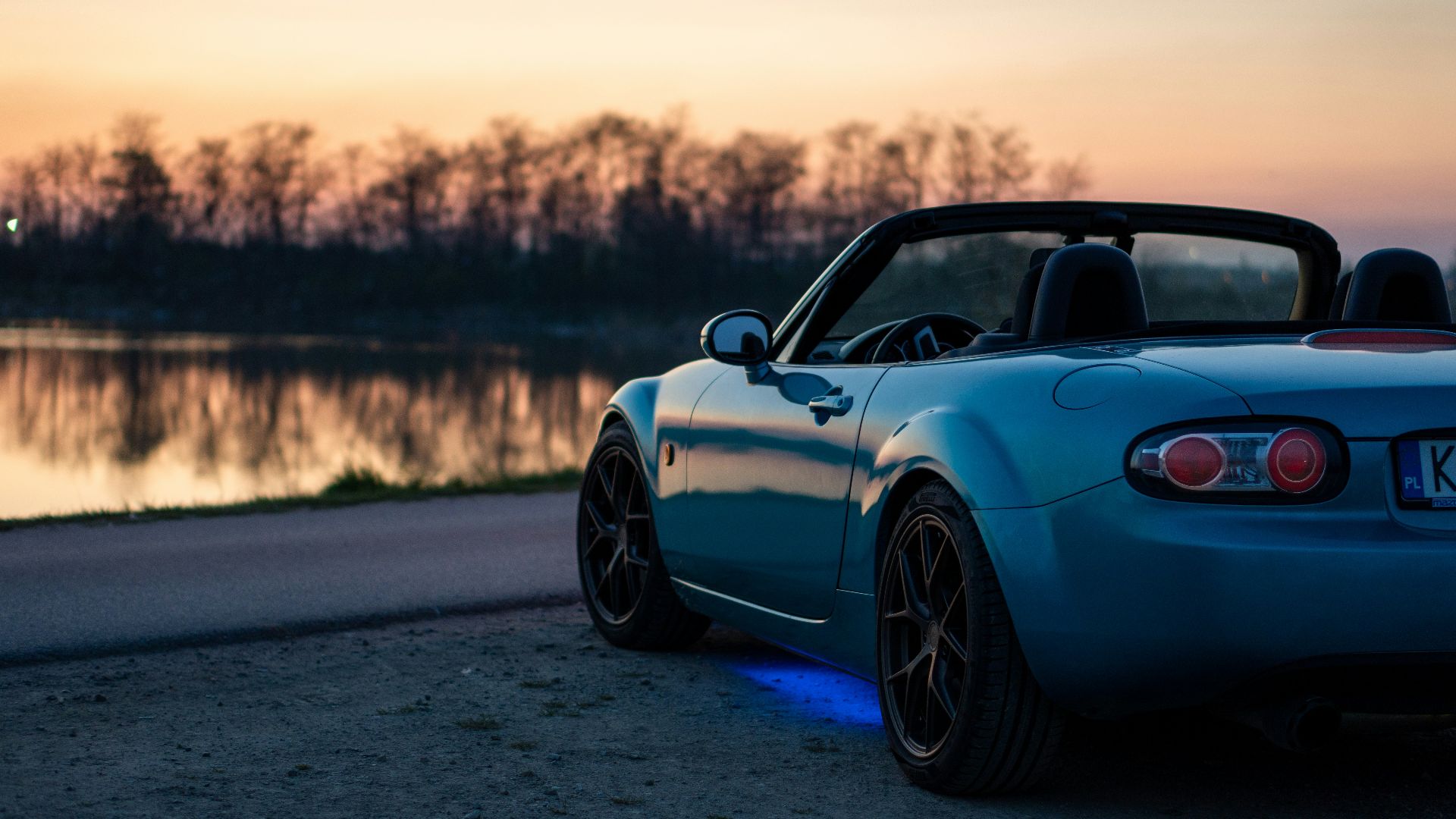 a blue sports car parked on the side of the road
