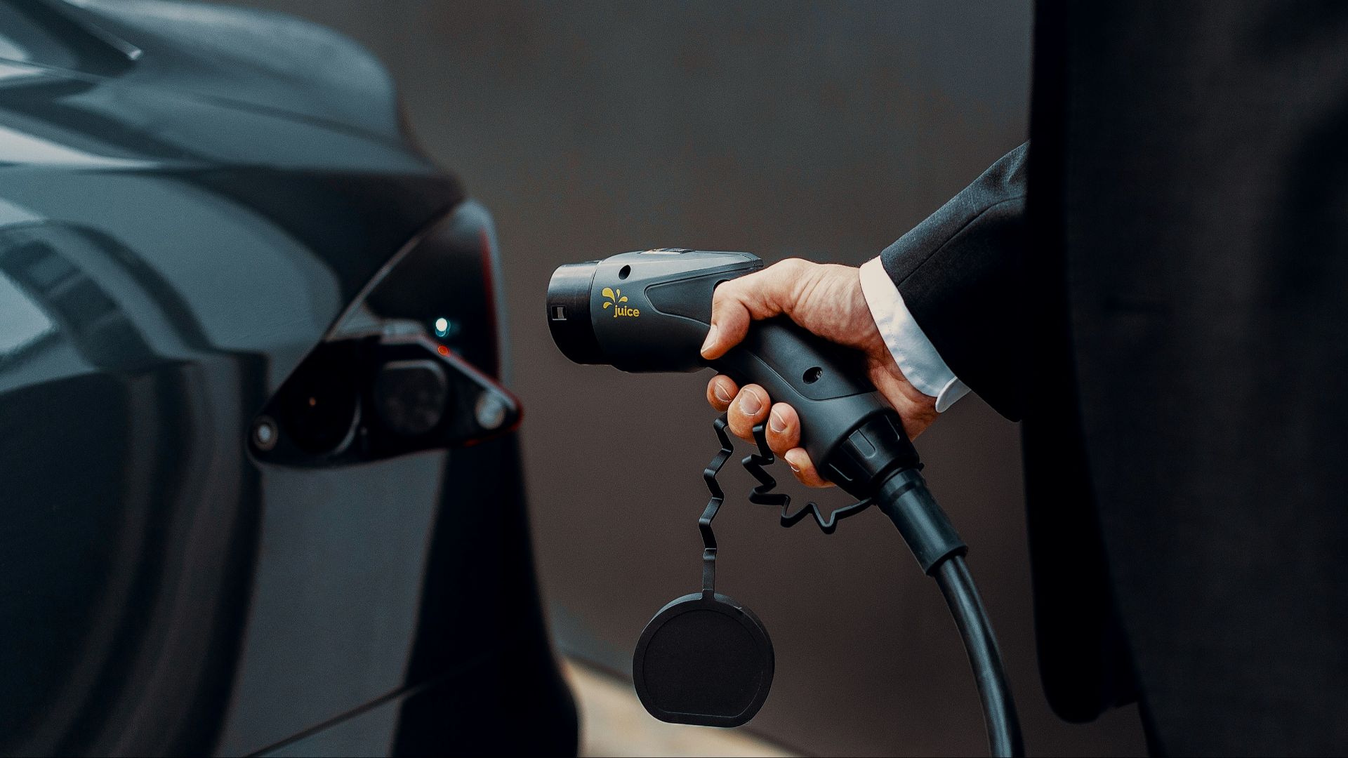 a man in a suit is pumping gas into a car
