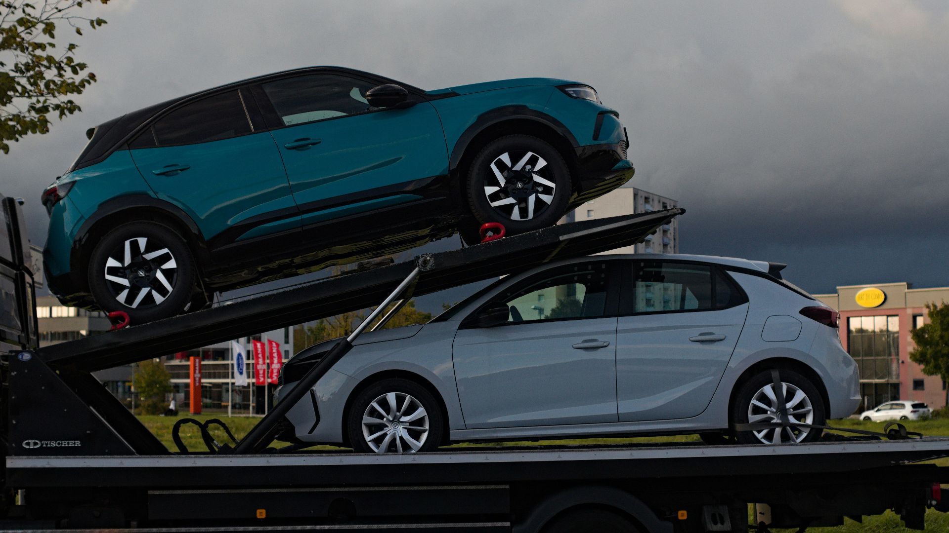 Two cars loaded onto a car carrier truck.