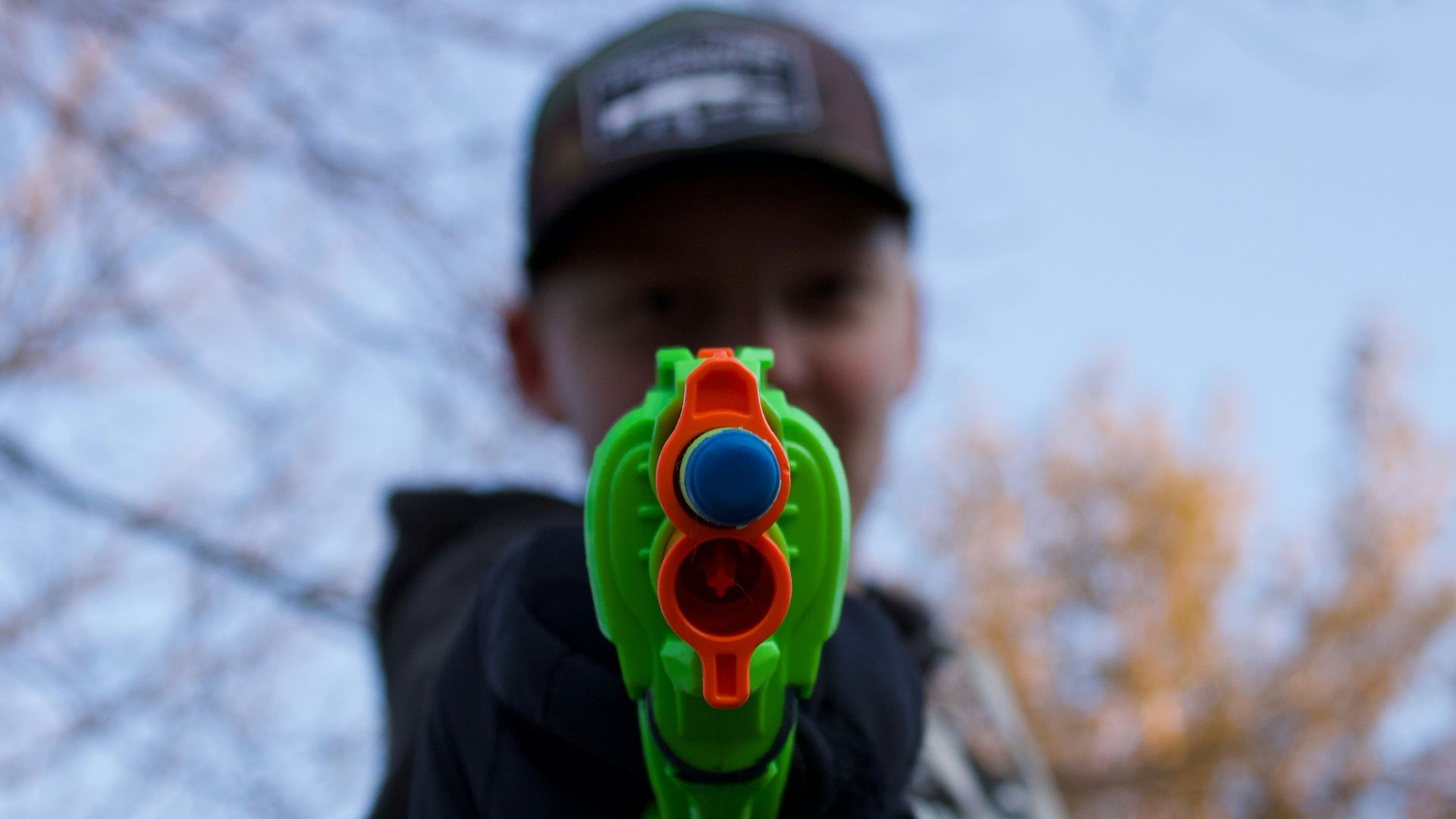 man in black and white hoodie with green and yellow round plastic toy
