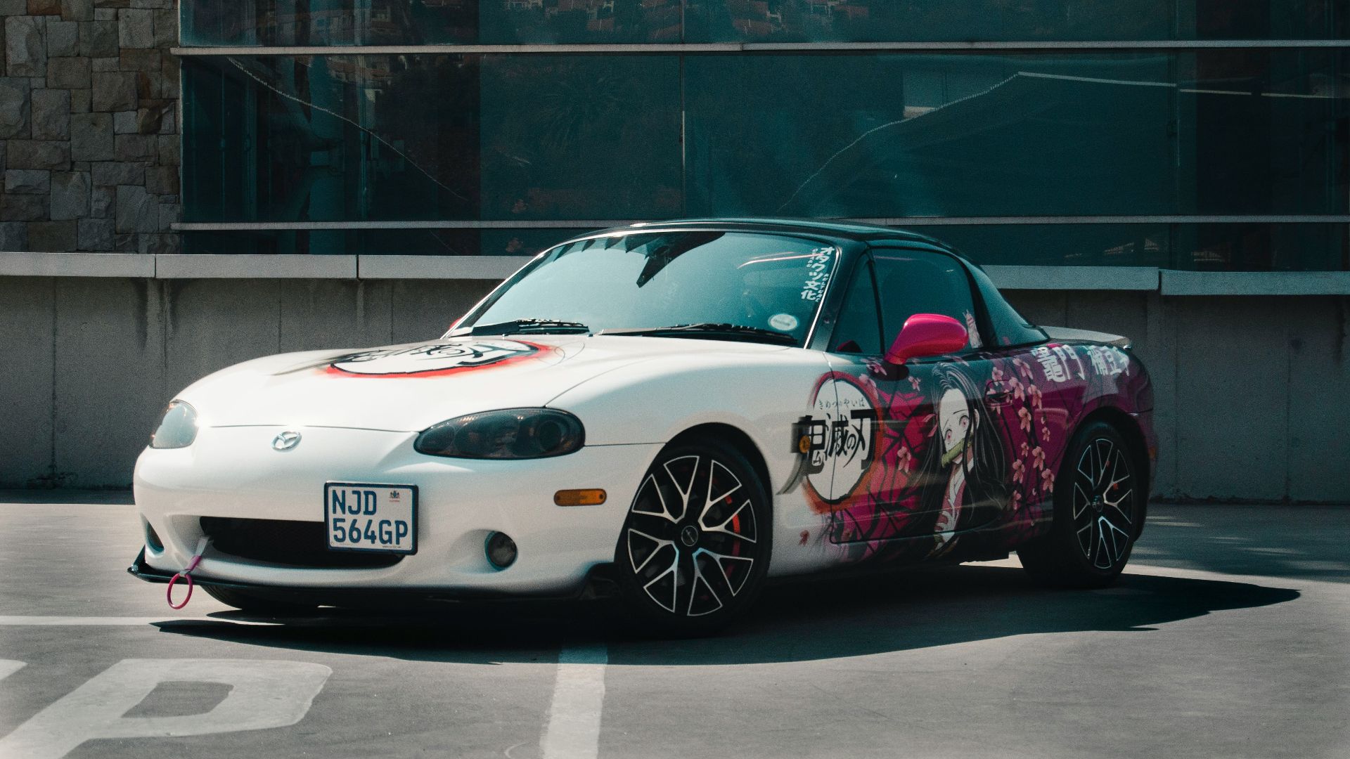a white sports car parked in a parking lot