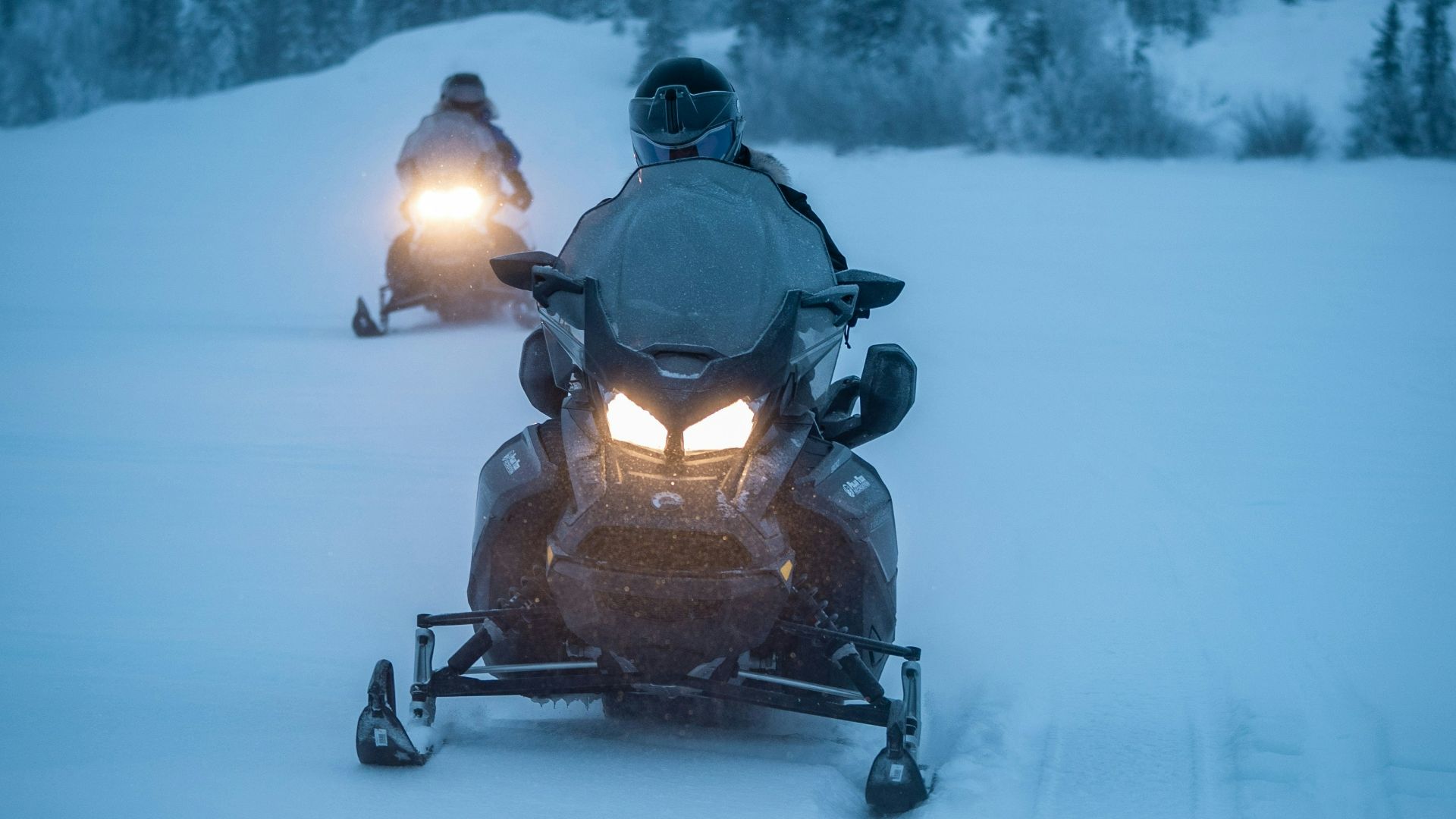 two persons riding snowmobile