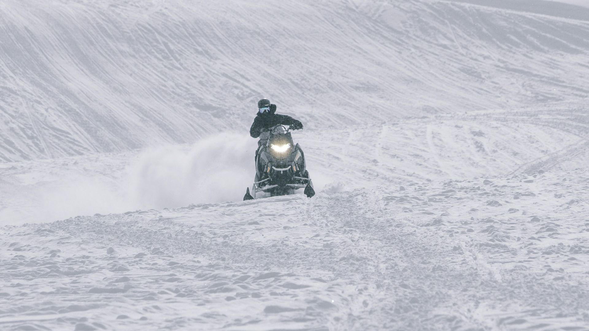 person riding on black motorcycle on snow covered field during daytime