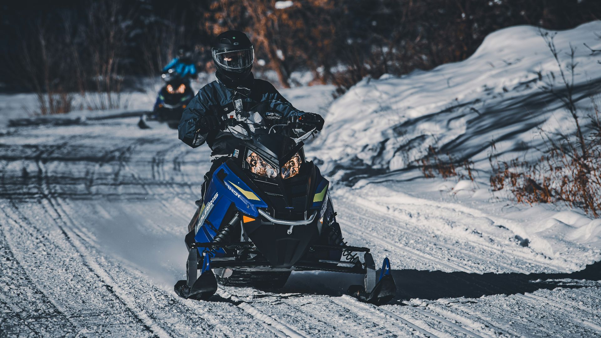 two people riding on a snowmobile in the snow