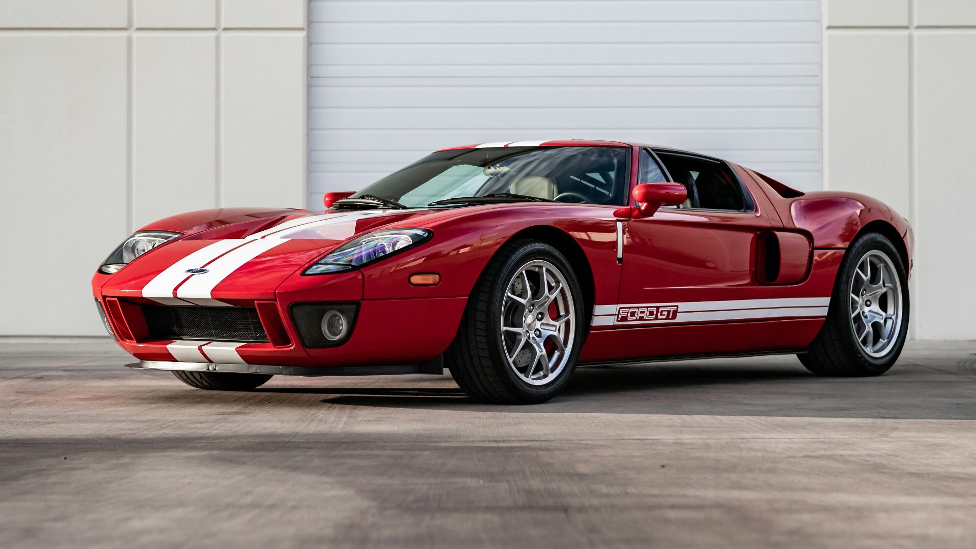 a red sports car parked in front of a garage